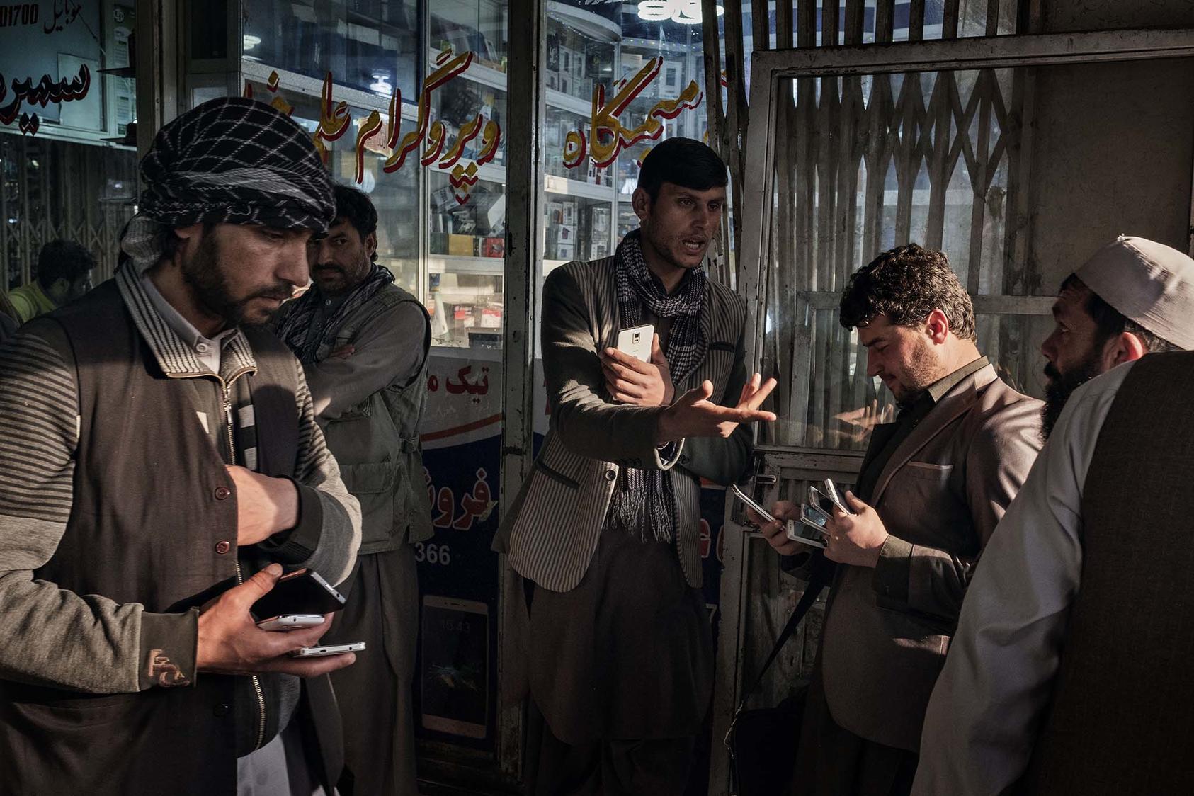 Afghans buy and sell used and new mobile phones, SIM cards and phone credit cards at a market in Kabul, Afghanistan, March 31, 2016. (Adam Ferguson/The New York Times)
