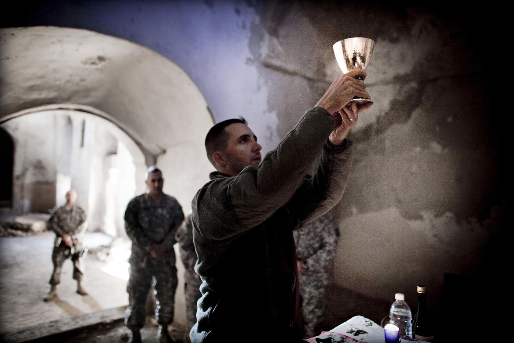 Major Jeffrey Whorton, an Army chaplain, gives mass to a small group of soldiers inside the ruins of the Saint Elijah Monastery near Mosul, Iraq. December 2009. (Eros Hoagland/The New York Times)