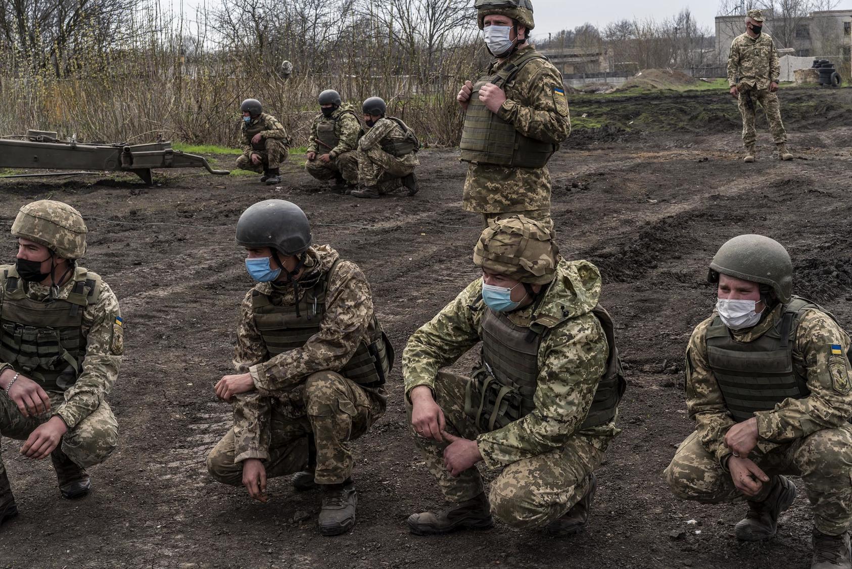 Ukrainian troops gather near the Russian-controlled part of Ukraine’s Donbas region April 19, as Russia massed its troops on the nearby border. Russia’s “hybrid war” on Ukraine joins military and non-military elements. (Brendan Hoffman/The New York Times)