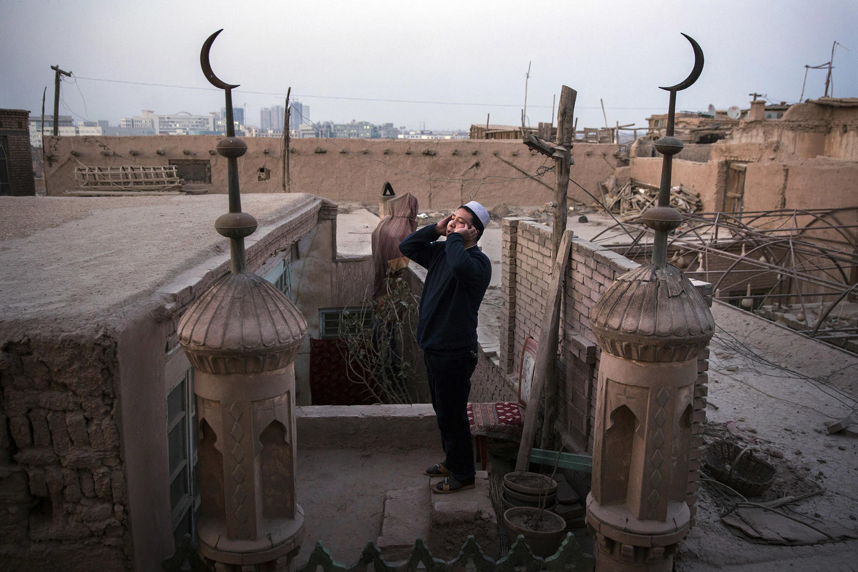 A Uyghur muezzin calls the evening prayer from the rooftop of a mosque in Kashgar, China. Documented evidence of human rights abuses in China’s Xinjiang region has painted a clear picture that Beijing is perpetrating mass atrocities against Uyghurs and other Turkic Muslim ethnic groups. (Adam Dean/The New York Times)