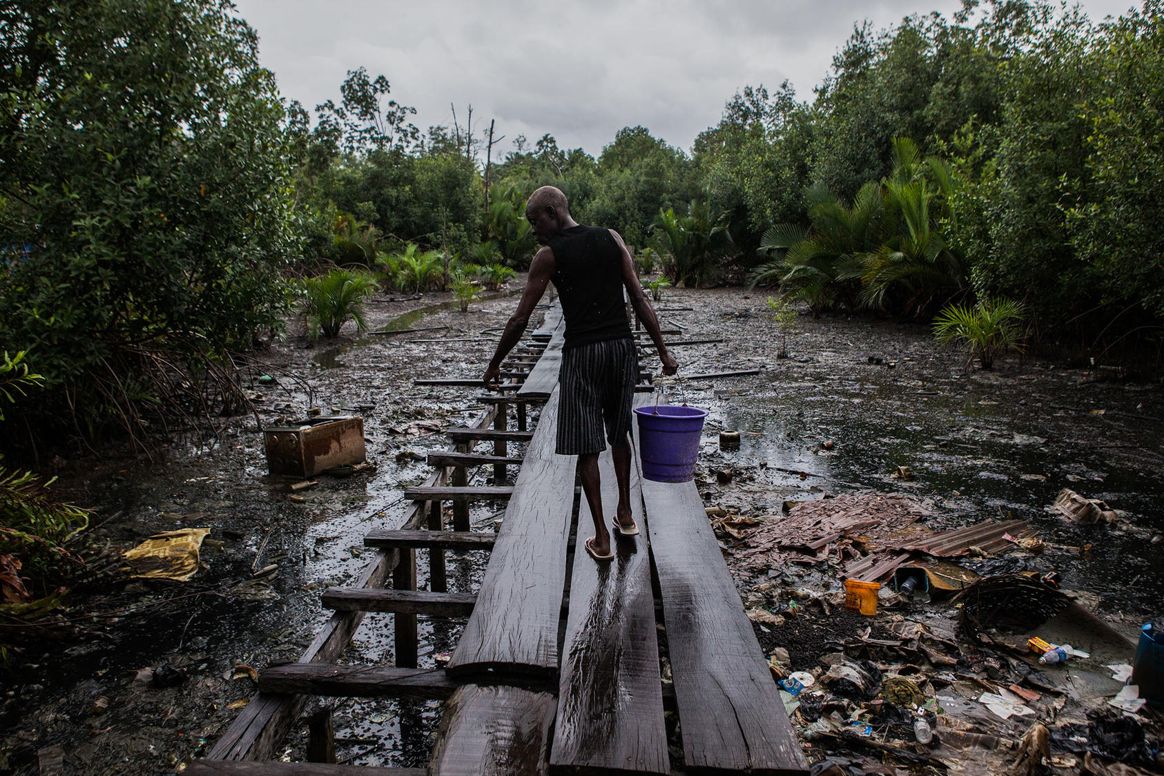 A polluted oil port in Nigeria, one of many fragile states where factions maintain stability by sharing the cash from oil exports. A global shift from oil will risk instability in such countries, USIP-funded research finds. (Jane Hahn/The New York Times)