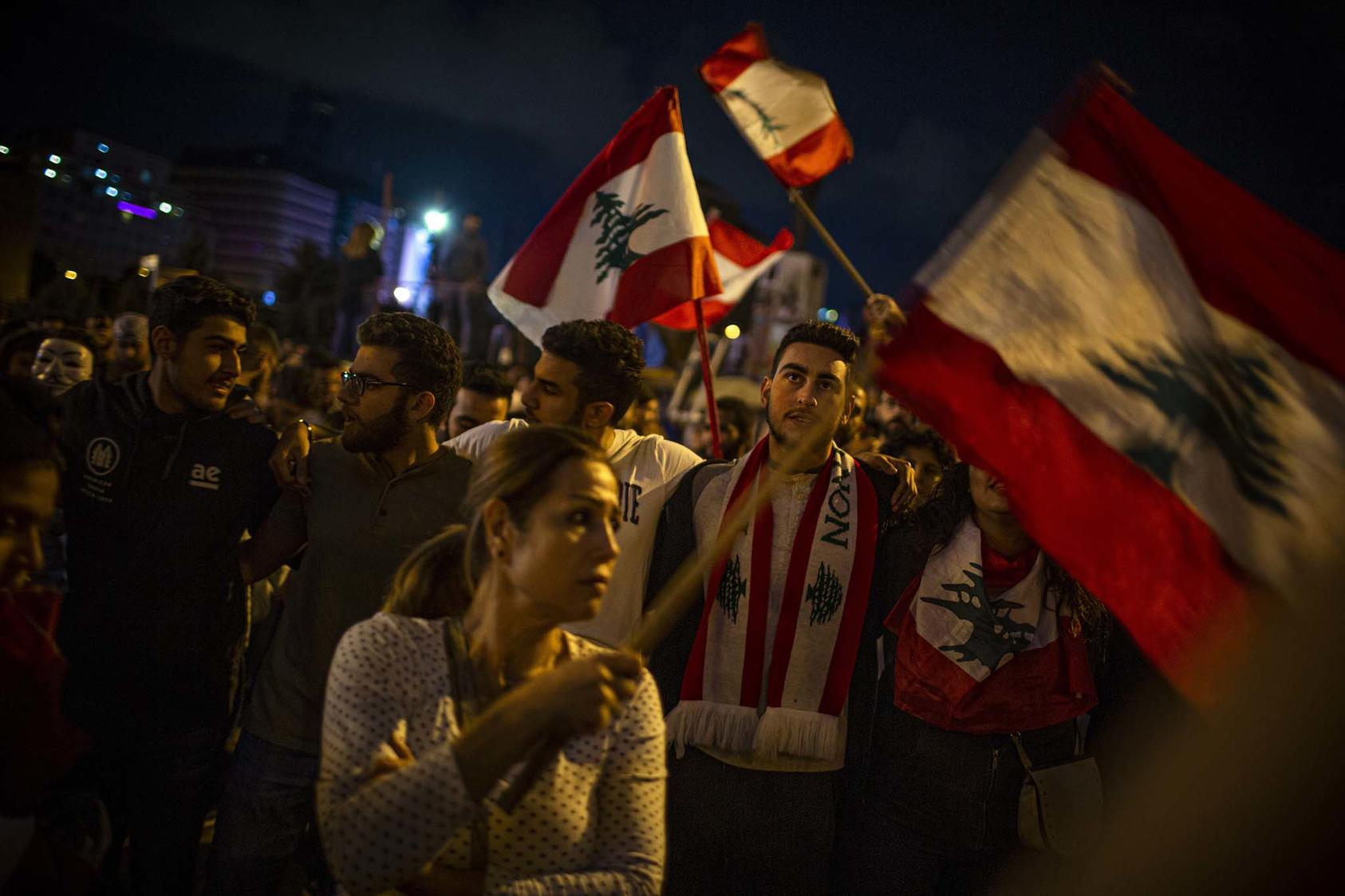 Anti-government protesters wave the flag of Lebanon as they gather in Martyr's Square in Beirut on Tuesday night, Oct. 29, 2019. (Diego Ibarra Sanchez/The New York Times)