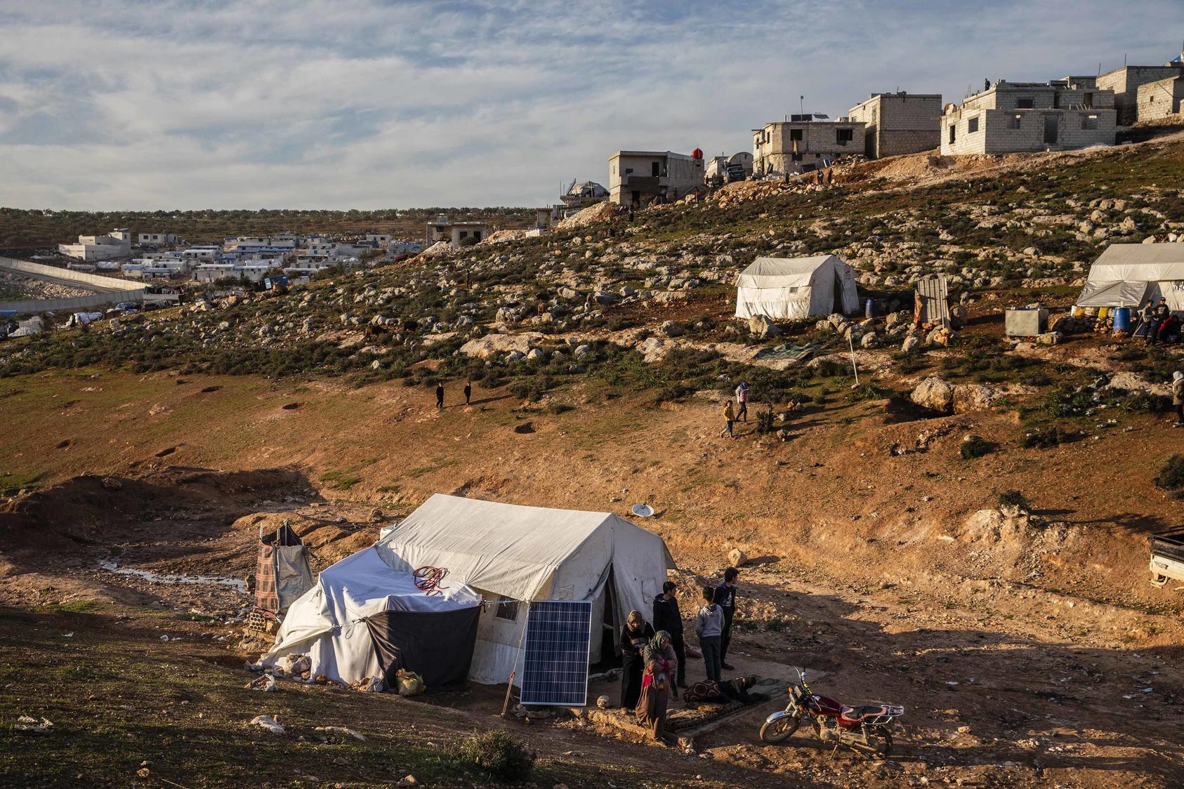 Several families share a tent pitched atop a sewer not far from Idlib, Syria, March 4, 2020. The potential closure of the last aid crossing, known as Bab al-Hawa, will exacerbate an already dire humanitarian situation. (Ivor Prickett/The New York Times)