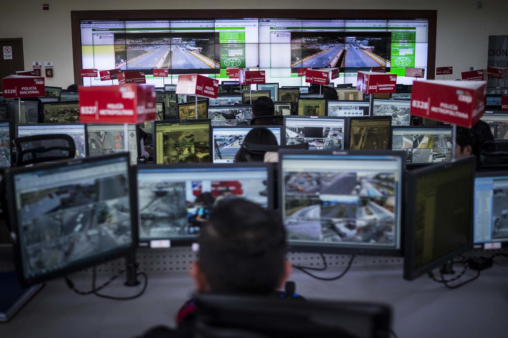 A control room in Ecuador's Emergency Response System. Cameras across the country send footage to monitoring centers like this one to be examined by police and domestic intelligence. The surveillance system’s origin: China. (Jonah Kessel/The New York Times)
