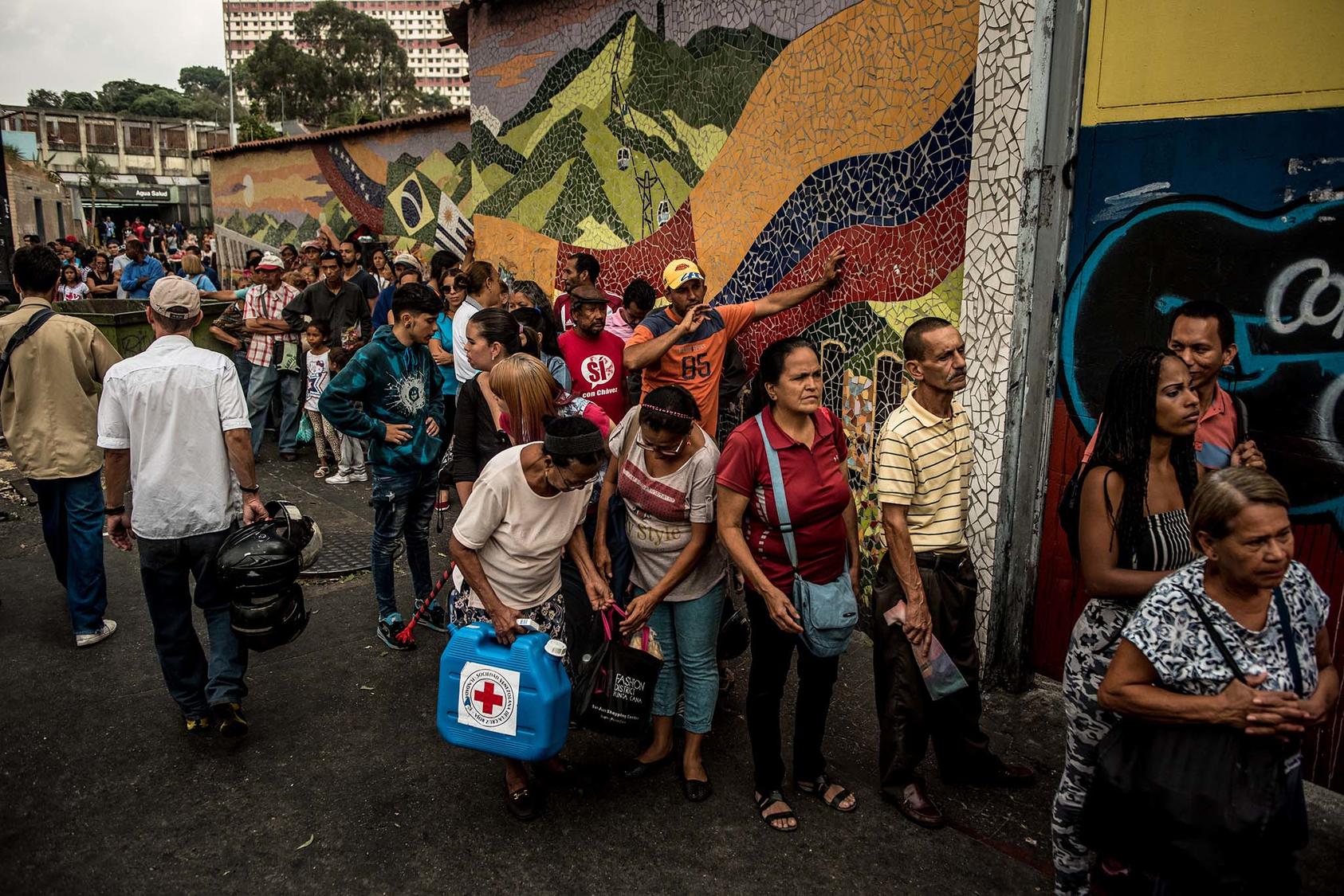 People wait in line as Red Cross workers distributed water containers and potable water purification tablets in Caracas, Venezuela, April 16, 2019. (Meridith Kohut/The New York Times)