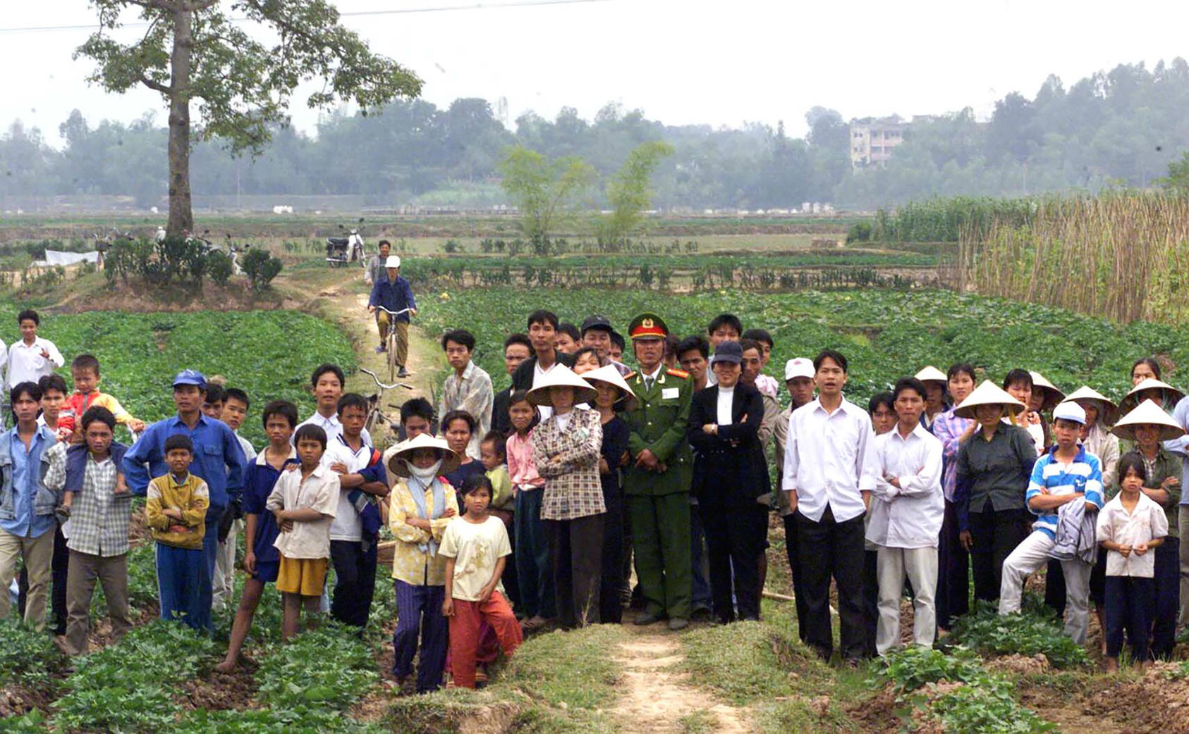 Residents of the village of Tien Chau watch a visit by American and Vietnamese teams searching the area in 2000 for the buried remains of a U.S. pilot shot down in the Vietnam War. (Paul Hosefros/The New York Times)