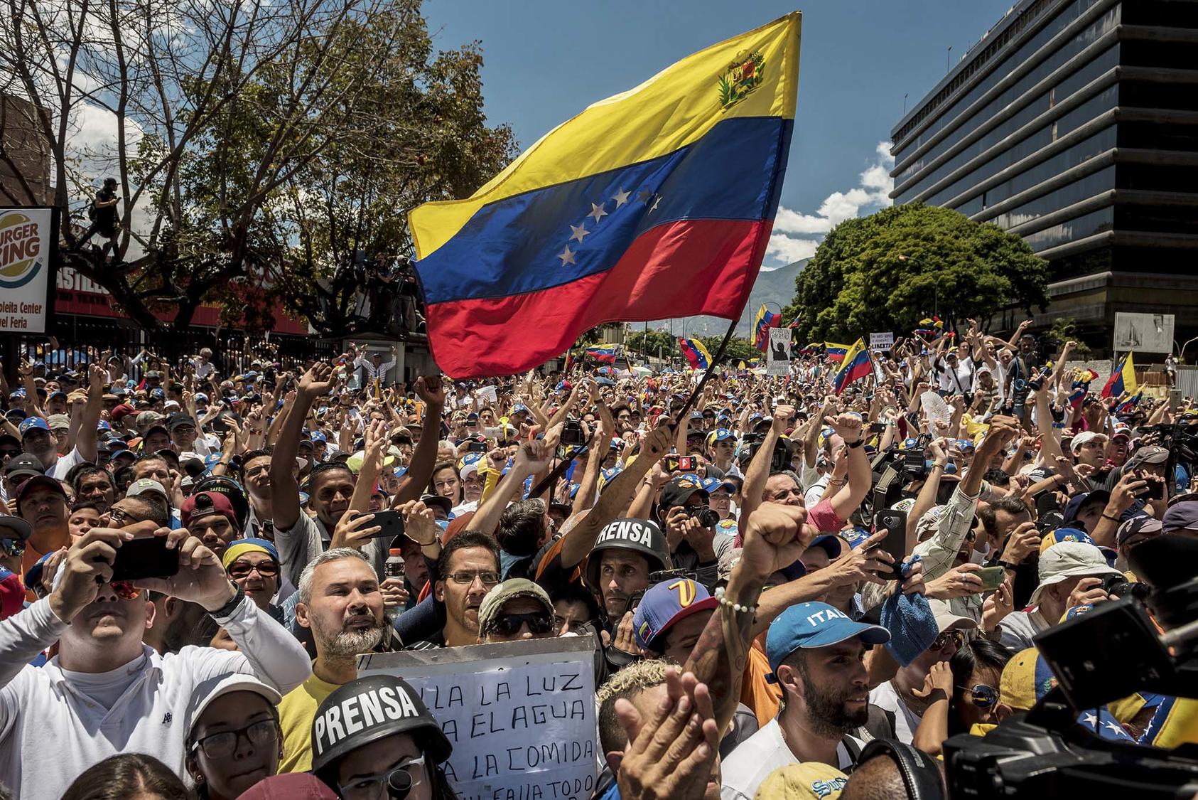 Opposition supporters watch Juan Guaidó, the Venezuelan opposition leader, speak out against Presidebt Nicolas Maduro in Caracas, April 6, 2019.