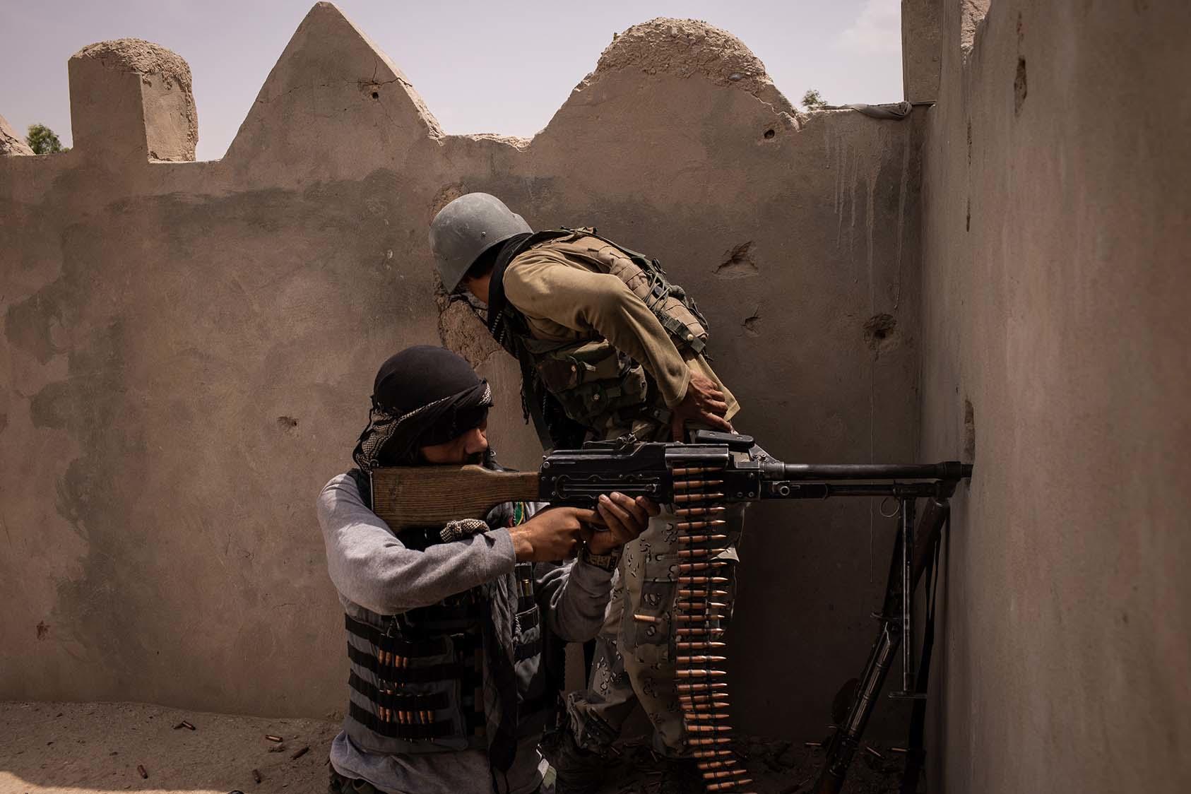 An Afghan soldier fires a machine gun at Taliban positions in Lashkar Gah, Afghanistan on May 10, 2021. (Jim Huylebroek/The New York Times)