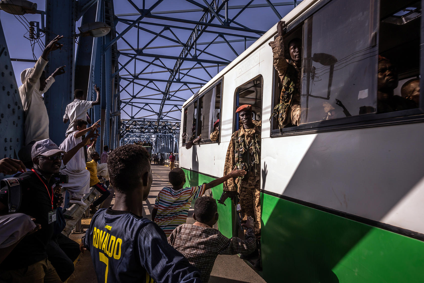 Protesters cheer as a bus carrying solders is driven over a bridge near the site of a sit-in outside military headquarters in Khartoum, Sudan. Tuesday, April 23, 2019. (Bryan Denton/The New York Times)
