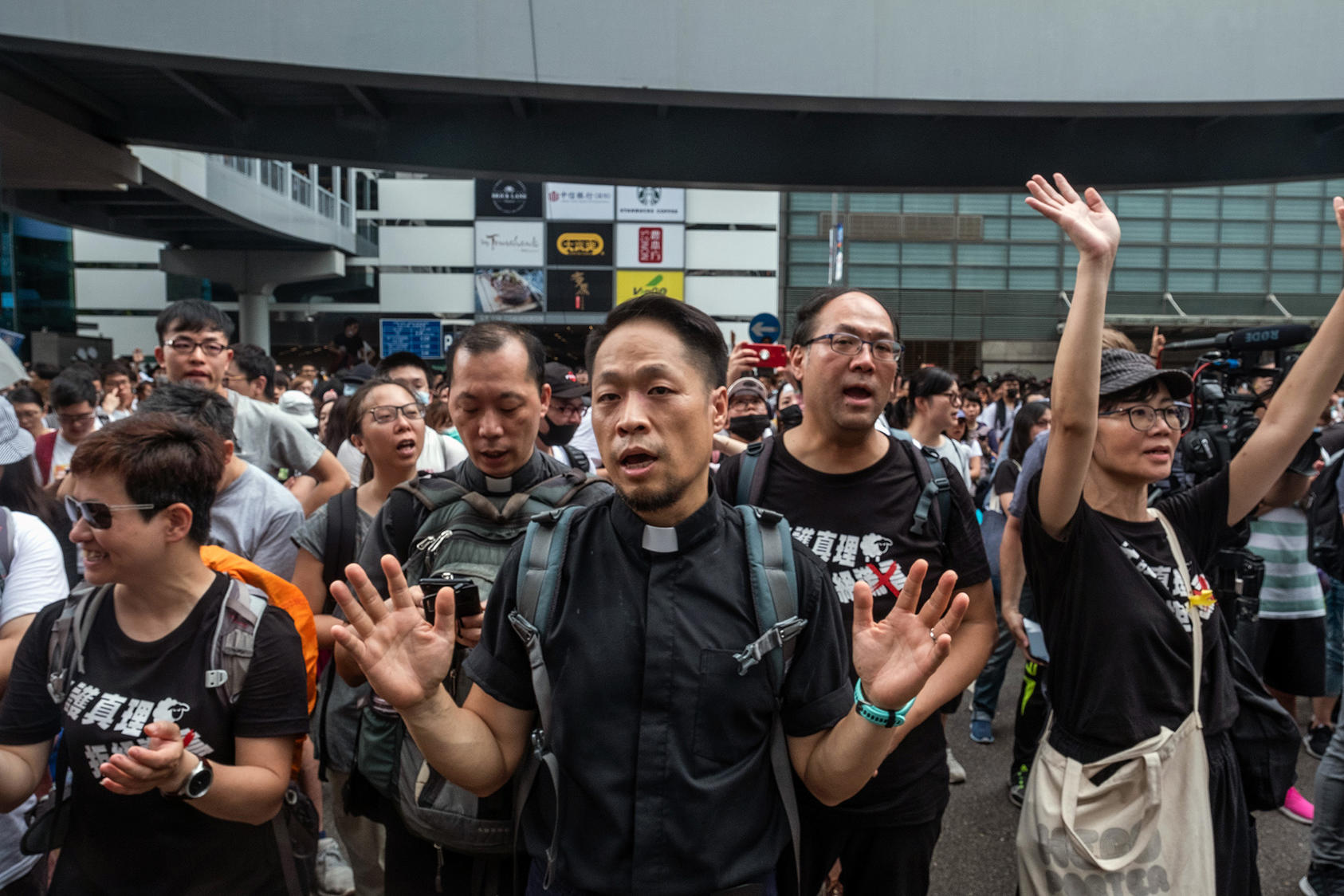 Democracy advocates in Hong Kong sing hymns outside the legislature in 2019 as they protest China’s seizure of control. Protesters adopted religious themes because religious gatherings are harder for police to break up. (Lam Yik Fei/The New York Times)