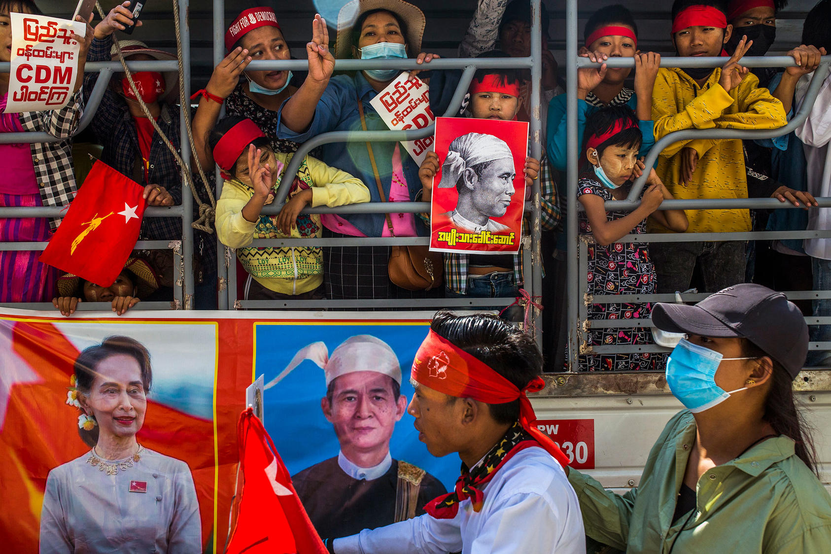 Protesters in Yangon, Myanmar with a poster of Daw Aung San Suu Kyi, the leader of the country’s ousted civilian government and head of the NLD, at lower left. Feb. 13, 2021. (The New York Times)
