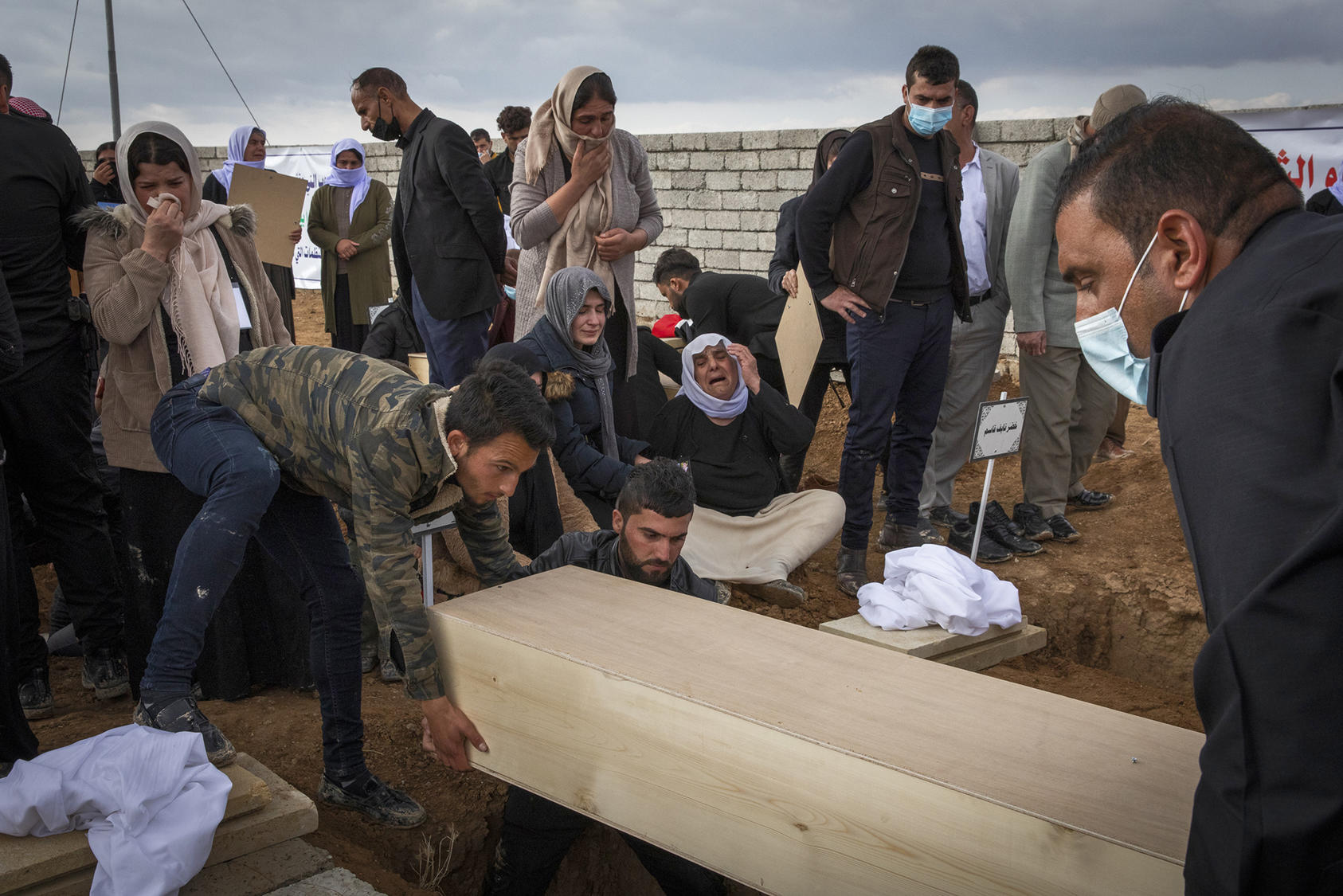 Yazidis in Kojo, Iraq, bury one of 103 men from the village killed by ISIS fighters and dumped in a mass grave in 2014. Thousands of Yazidi women and children, whom ISIS seized as slaves, remain missing. (Ivor Prickett/The New York Times)