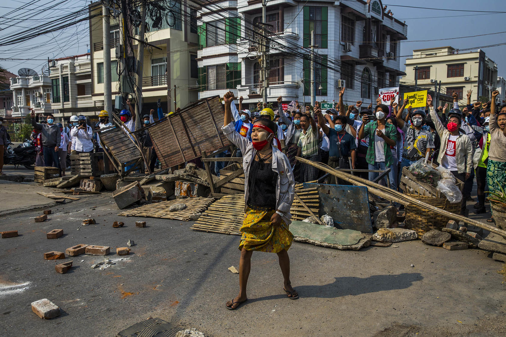 Protesters shout from behind a makeshift barricade in Mandalay, Myanmar, as police and military forces crack down on protests against the military coup. February 28, 2021. (The New York Times)