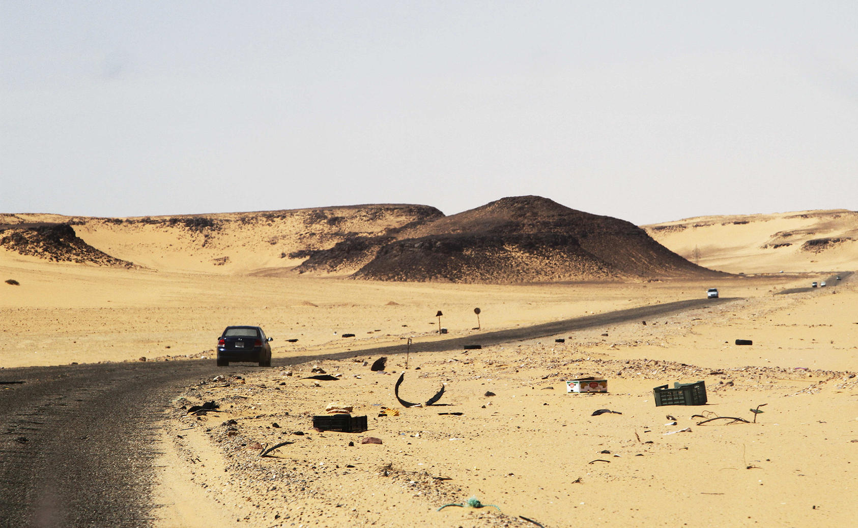 A car drives along the road between Sebha and Ubari in southwestern Libya on December 24, 2013. Both cities are ethnically and tribally mixed, making them flash points for conflict. (Paul Schemm/AP)