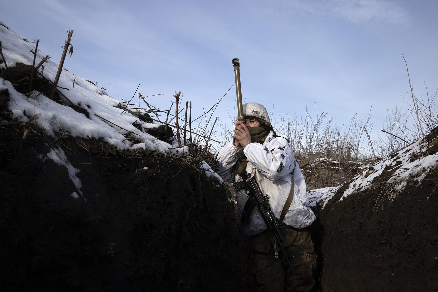 A Ukrainian soldier uses a periscope to survey a front line with Russian proxy forces in eastern Ukraine. Russian troops remain massed at Ukraine’s borders for a possible invasion to escalate the eight-year-old war. (Tyler Hicks/The New York Times)