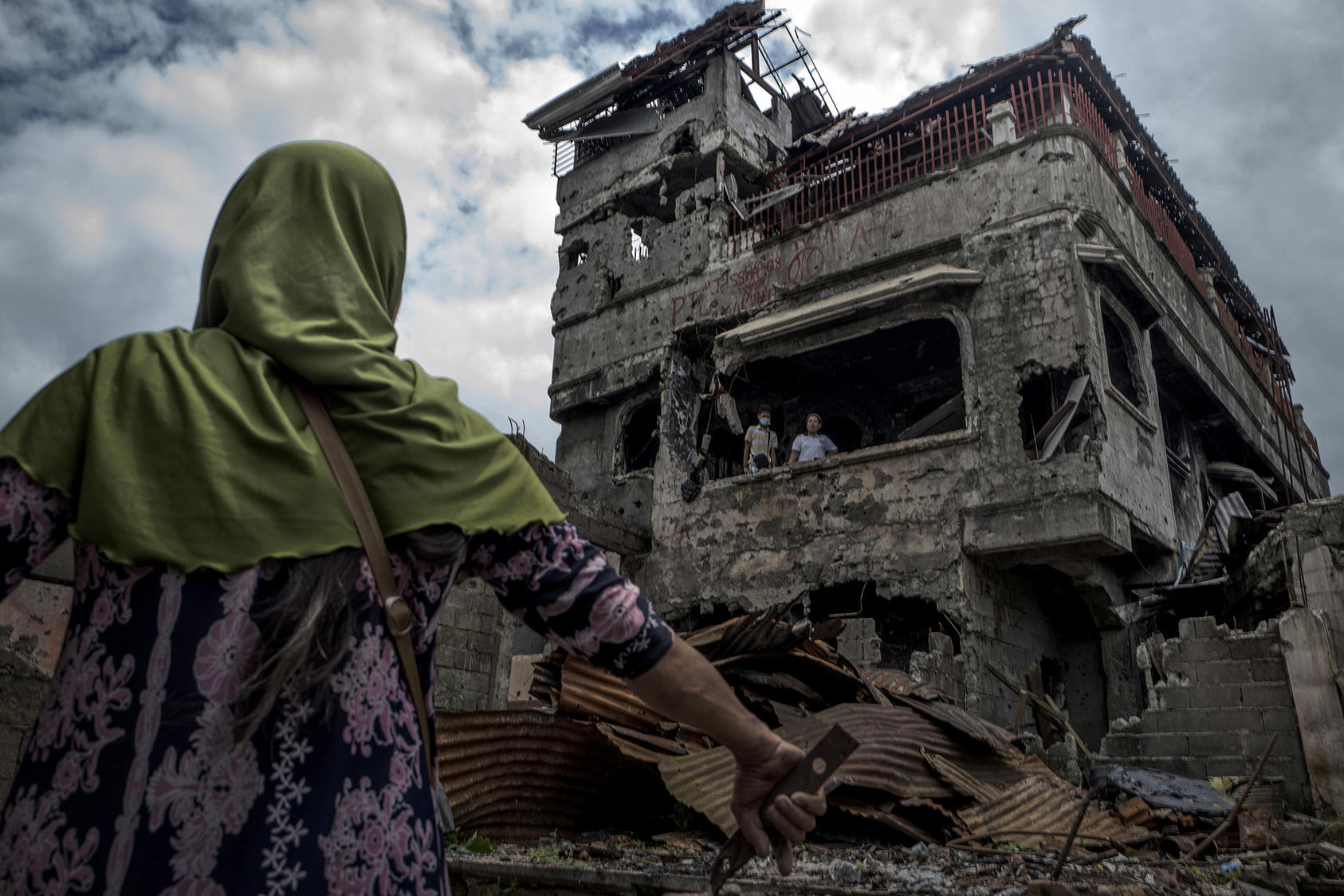 Residents return briefly to examine the wreckage of their home in Marawi, a city in the southern Philippines. April 8, 2018. (Jes Aznar/The New York Times)