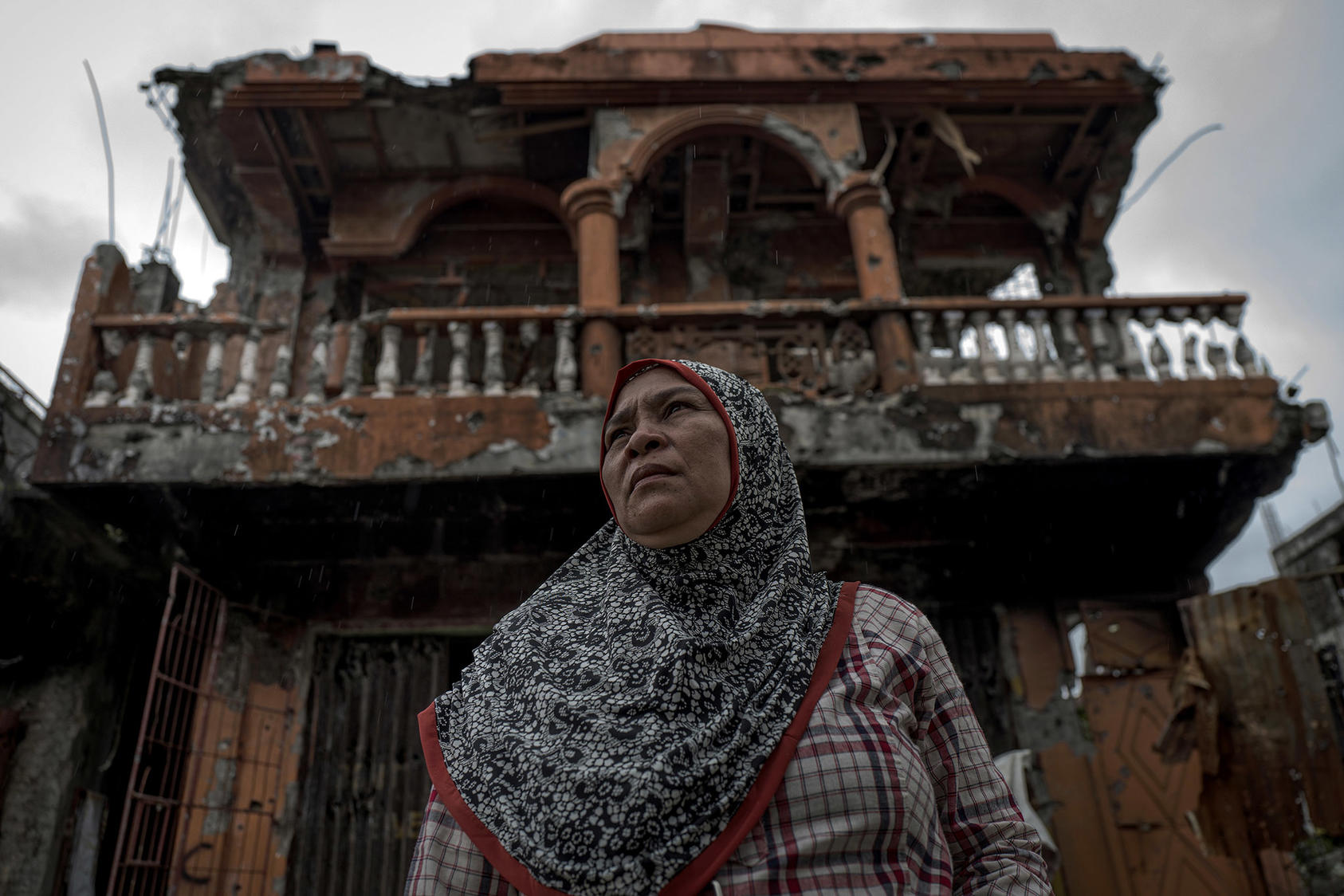 Lenang Cali stands in front of the wreckage of her home and bakery shop during a brief return to Marawi, in the southern Philippines. April 8, 2018. (Jes Aznar/The New York Times)