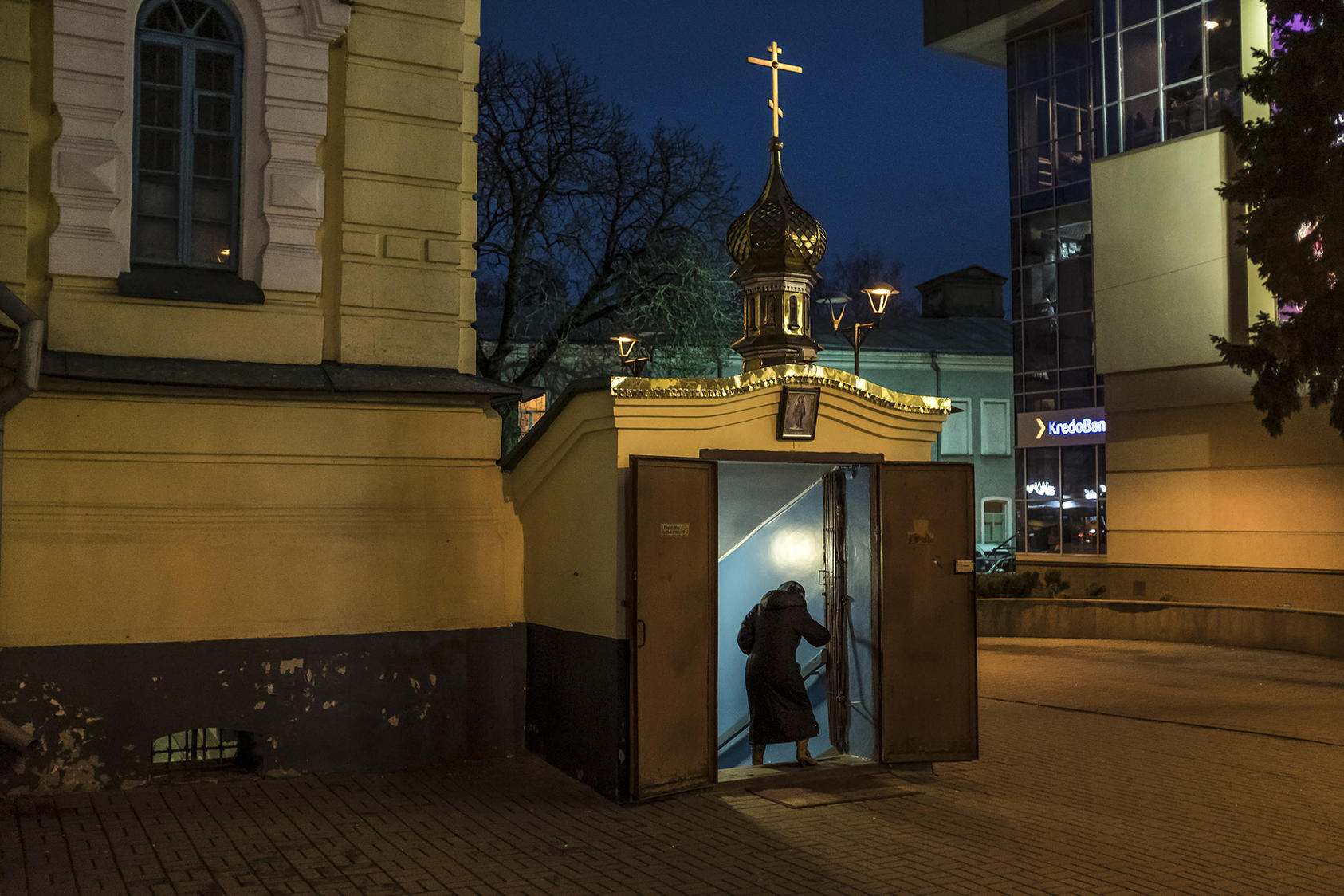 A worshiper enters the basement of the Church of the Archangel Michael in Rivne, Ukraine, where the Moscow-led Orthodox branch holds services. December 9, 2018. (Brendan Hoffman/The New York Times)