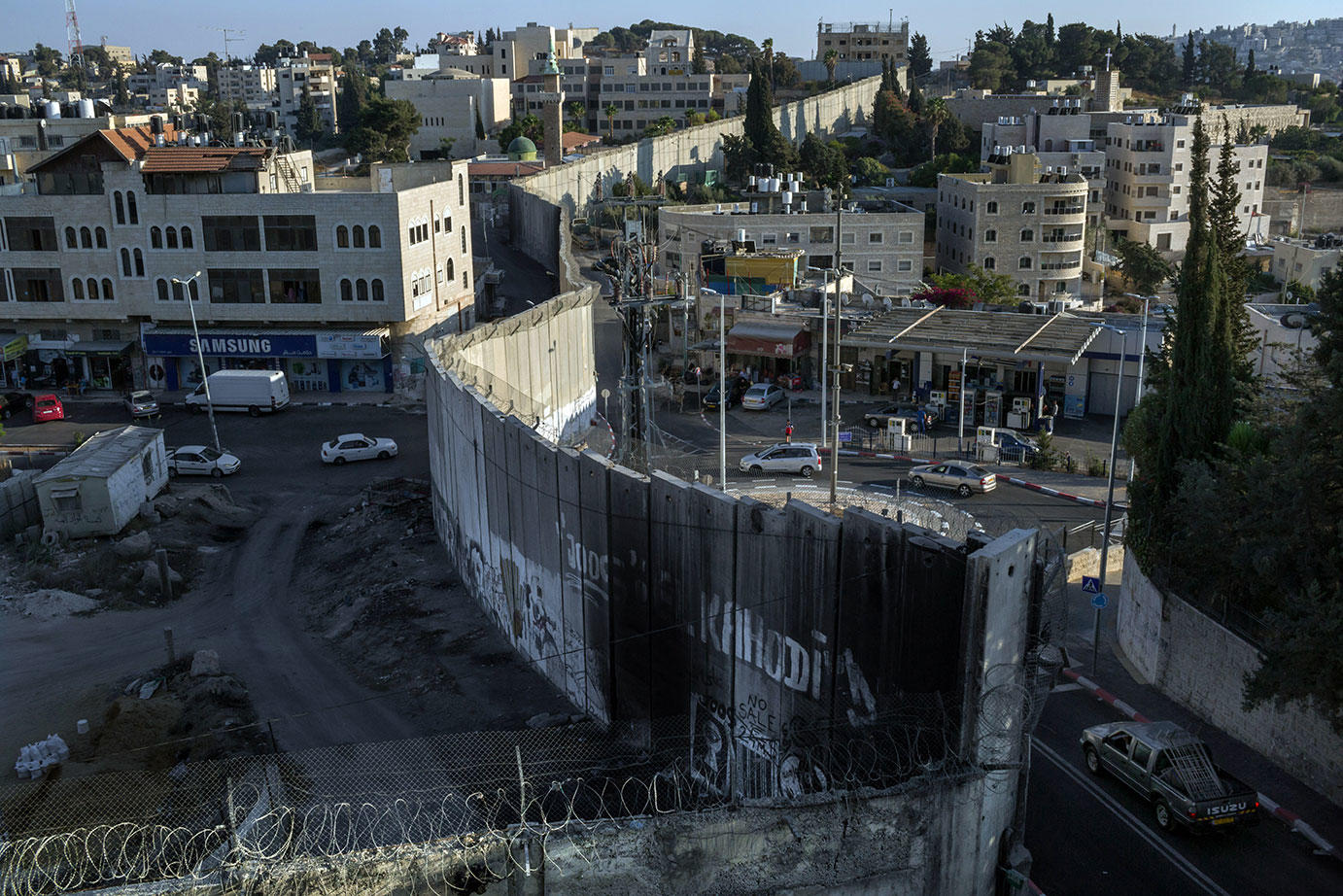 The wall dividing the Palestinian town of Abu Dis in the West Bank, left, from east Jerusalem. September 12, 2019. (Mauricio Lima/The New York Times)