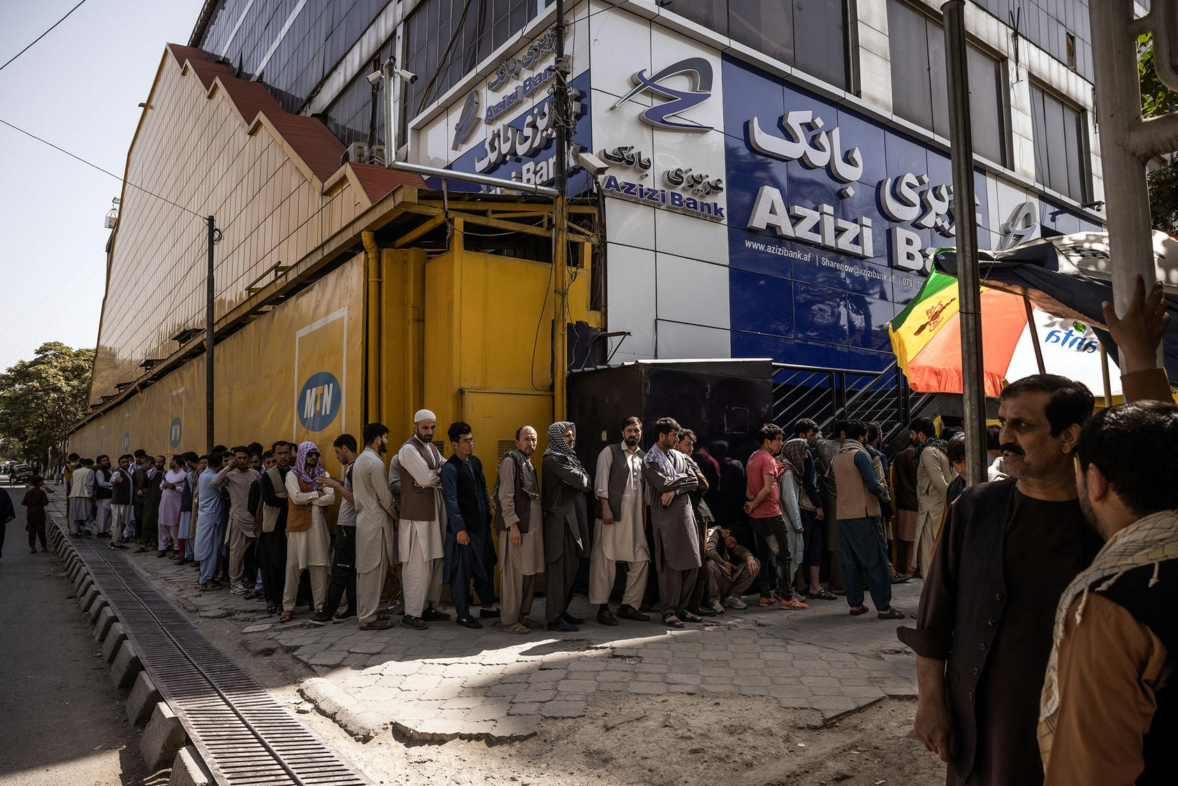 A line of people waiting outside a bank in Kabul, Afghanistan. August 29, 2021. (Jim Huylebroek/The New York Times)