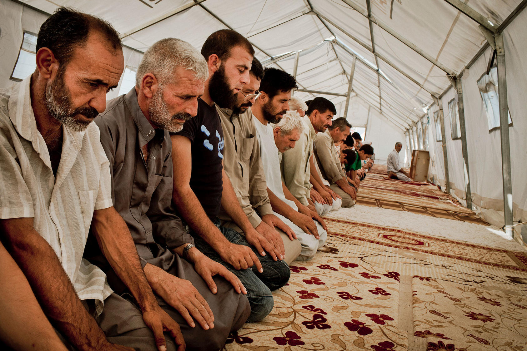 Syrian men praying at a tent encampment for Syrian refugees, in Islahiye, Turkey. July 15, 2012. (Tomas Munita/The New York Times)