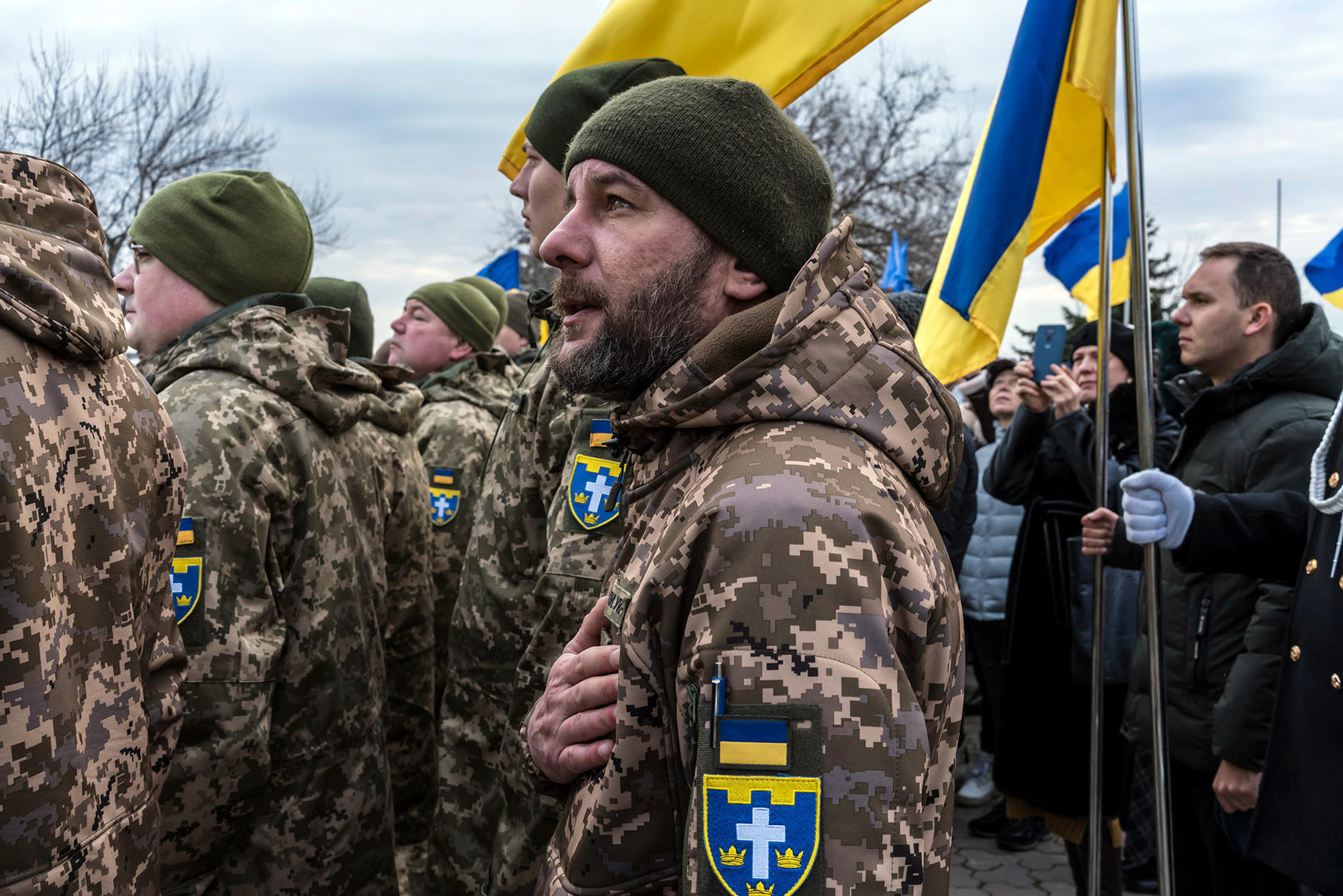 Soldiers sing their national anthem as the country faced Russia’s military buildup before the new invasion began in February. A million Ukrainians have fled the country since the new war began. (Brendan Hoffman/The New York Times)
