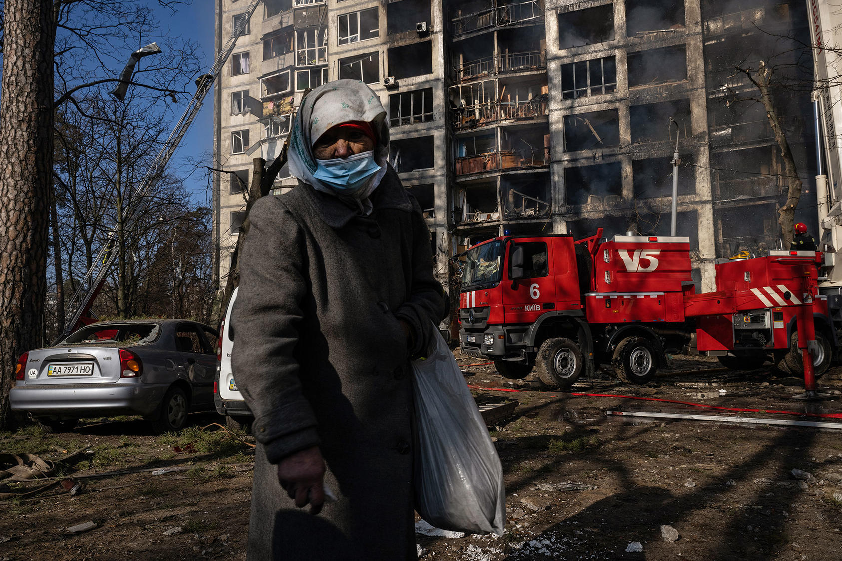 A woman in Kyiv passes crews battling flames in apartments rocketed by Russia’s army. Ukrainians’ furious self-defense may be forcing Vladimir Putin to rethink his options. But he will concede only what he is forced to. (Lynsey Addario/The New York Times)