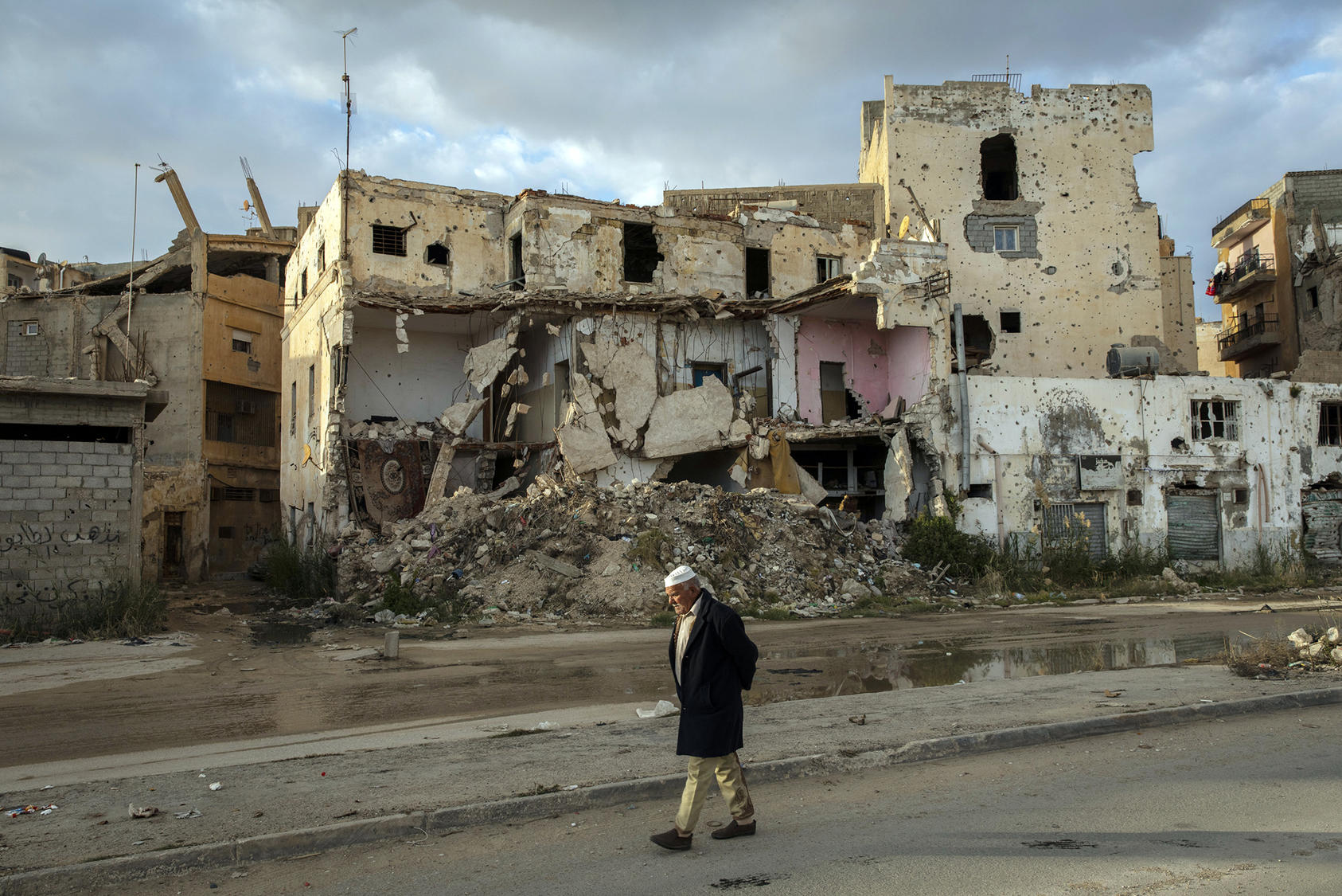 A man walks past the ruins left by years of conflict in the historic center of Benghazi, Libya, on Jan. 20, 2020. A new U.S. strategy aims to address the underlying drivers of conflict in countries like Libya.    (Ivor Prickett/The New York Times)