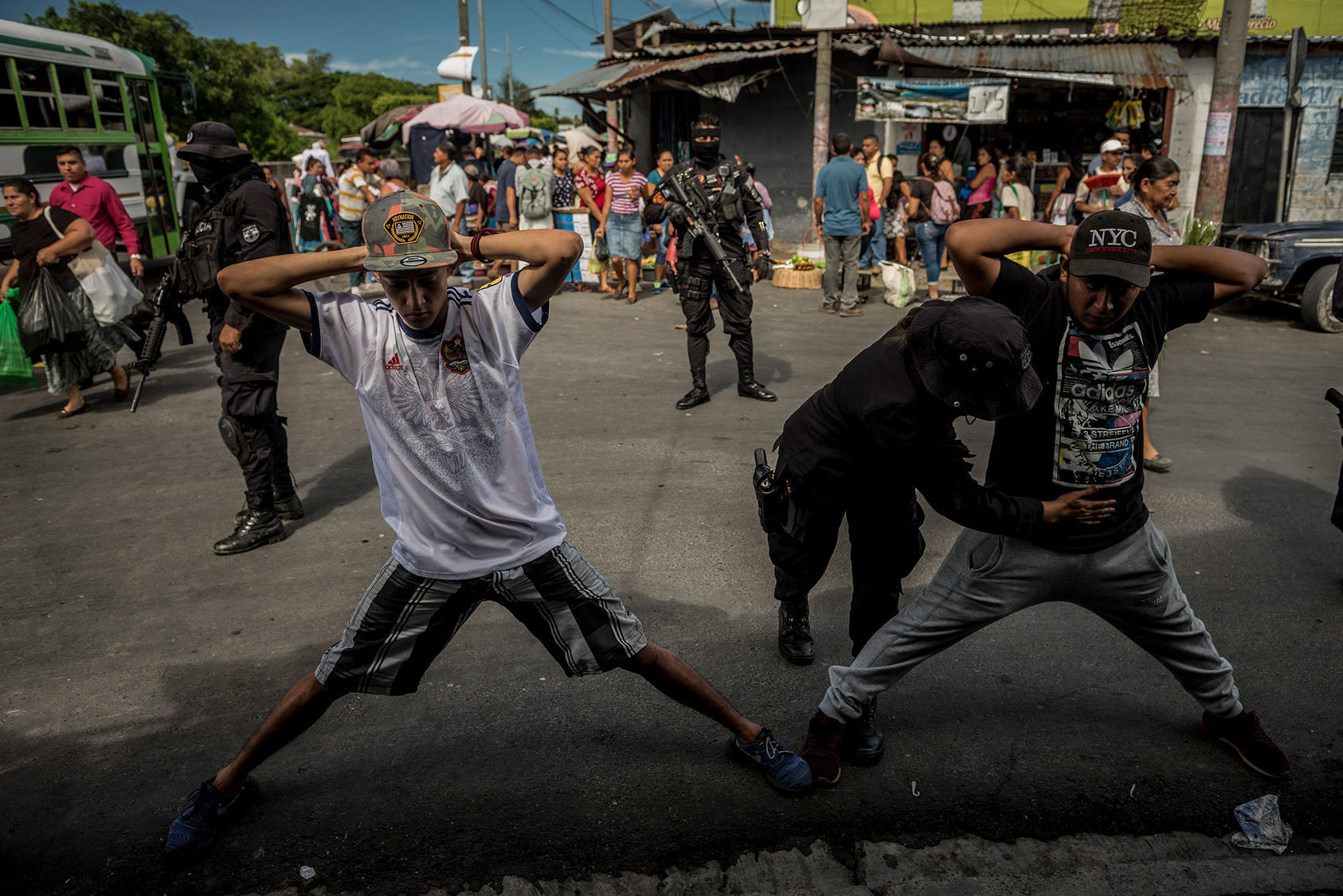 Agentes de policía detienen y requisan a dos hombres mientras patrullan el mercado de San Martín, donde se ha informado de actividad frecuente de pandillas, en San Salvador, el 26 de agosto de 2018. (Meridith Kohut/The New York Times)
