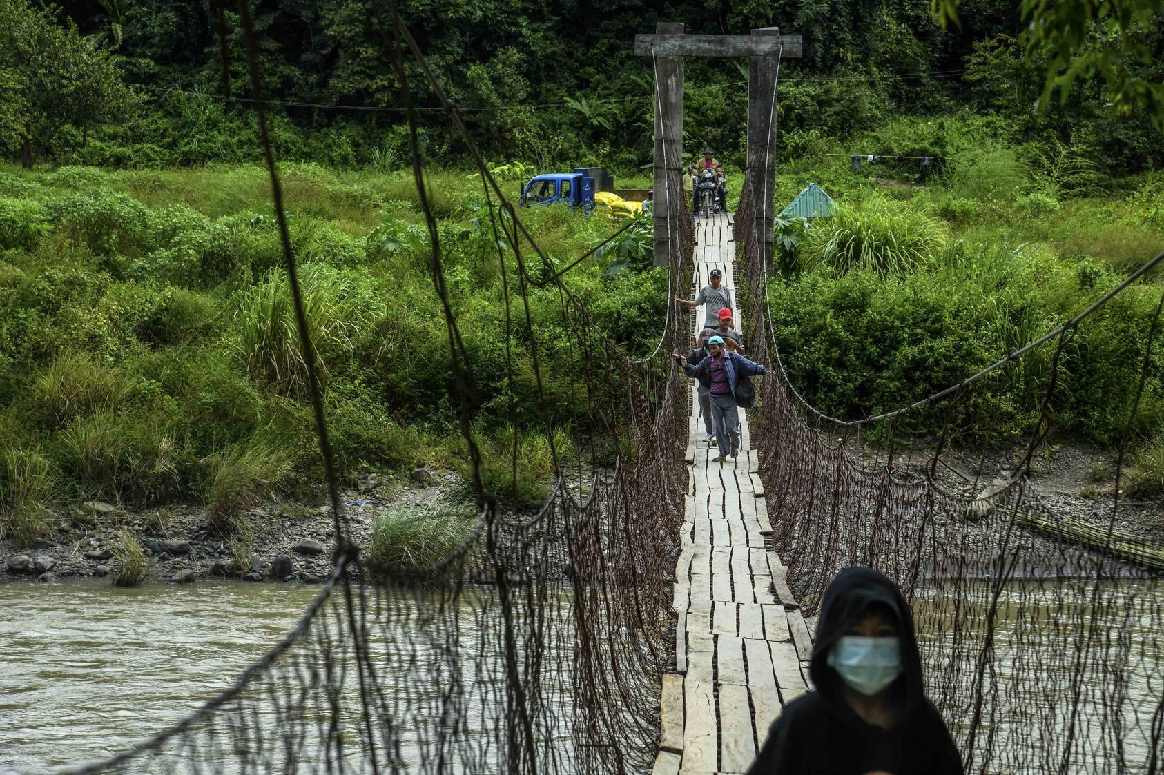 Refugees cross a suspension bridge from Myanmar into India, Oct. 16, 2021. An estimated 22,000 refugees have entered India from Myanmar since February 2021 military coup. (Atul Loke/The New York Times)