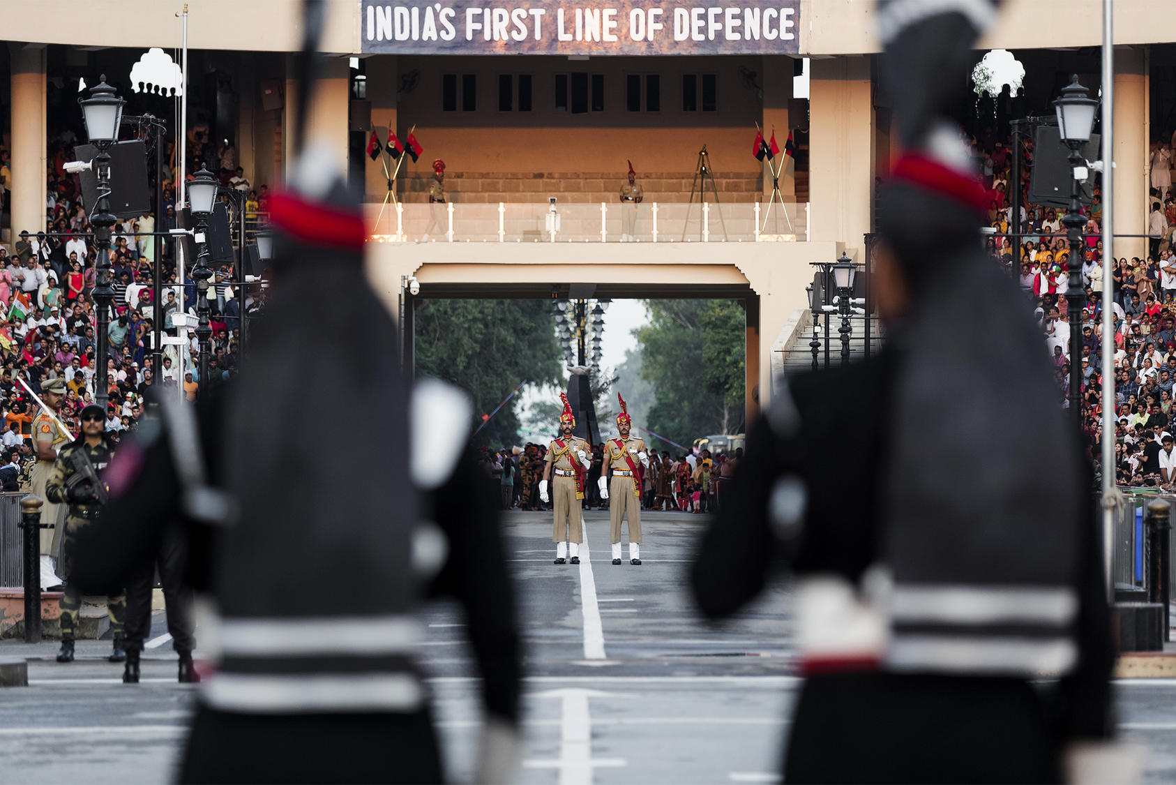 Pakistani, foreground, and Indian border guards mimc each other's movements during their daily ceremonial face off, at the Wagah-Attari border crossing, Sept. 28, 2019. (Mustafa Hussain/The New York Times)