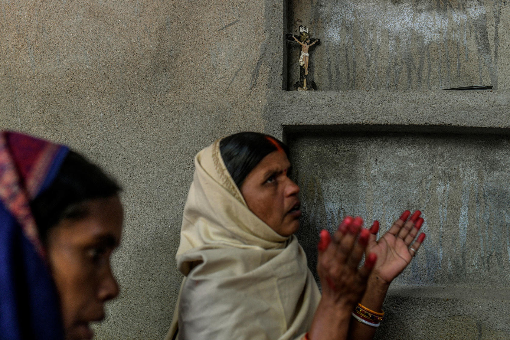 A small crucifix sits on a shelf at prayer meeting in secret amid an uptick in violence against Christians, in a village in the state of Bihar, India. February 12, 2021. (Atul Loke/The New York Times)]