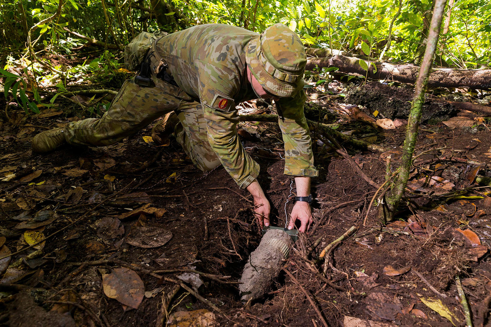 An Australian Army soldier places a charge on a World War II naval round in the Solomon Islands during Operation Render Safe 2019. (LSIS Kieren Whiteley/Australia Department of Defence)