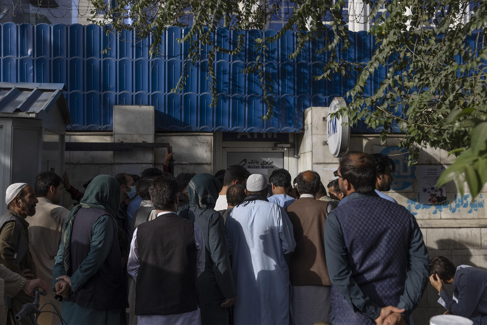 People wait in line to use an ATM machine at an Azizi Bank branch in Kabul, Afghanistan on Wednesday, Aug. 25, 2021. (Victor J. Blue/The New York Times)