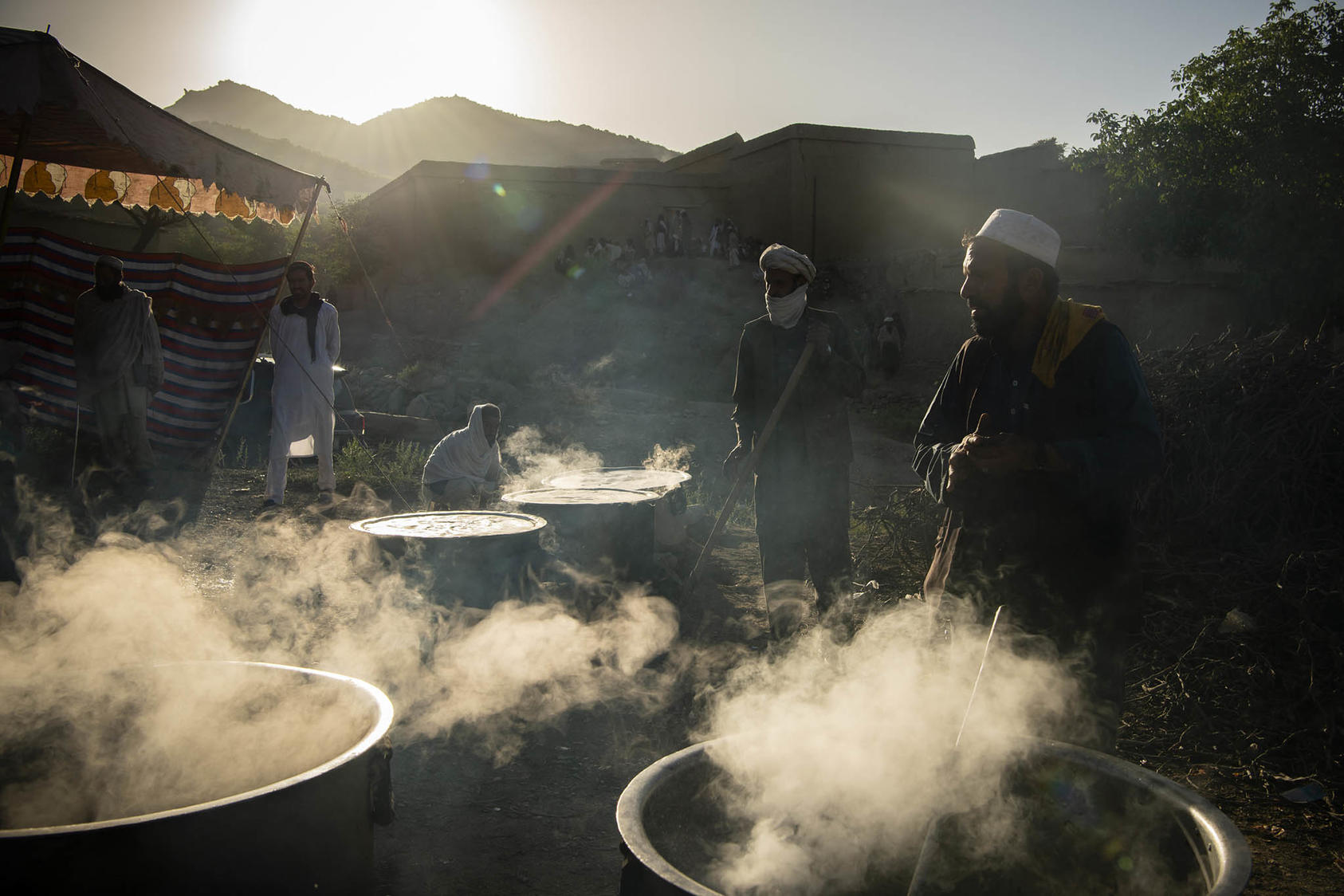 A local charity organization cooks vats of food to aid people affected by the earthquake, in the Gayan district of Afghanistan, June 24, 2022. (Kiana Hayeri/The New York Times)