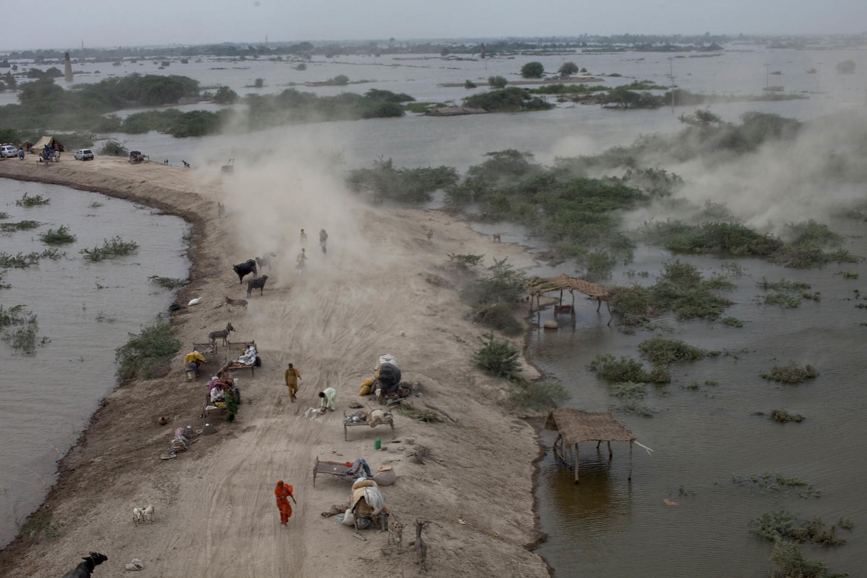 After evacuating the town of Sujawal from rising floodwater, displaced Pakistanis seek refuge on a narrow strip of land outside of the town where food and medical supplies are limited, in Pakistan, Aug. 29, 2010. (Tyler Hicks/The New York Times)