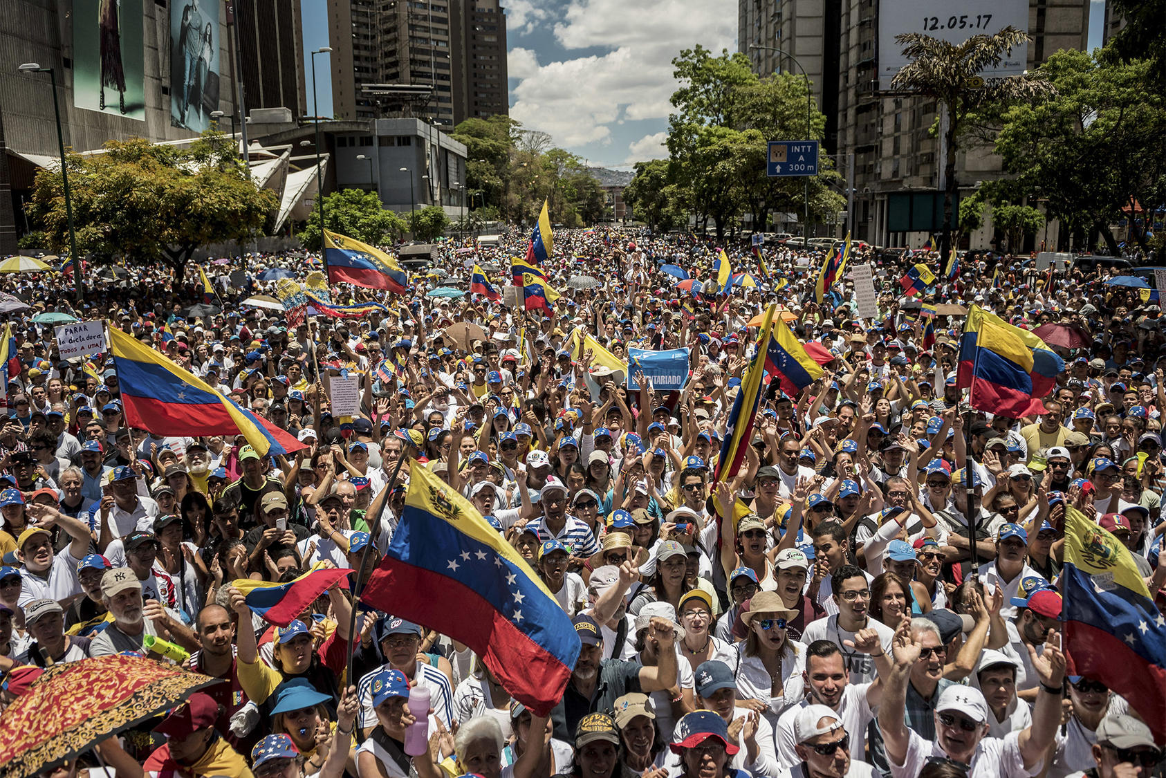 Opposition supporters wave Venezuelan flags as they march across eastern Caracas to show their discontent with the Maduro government. April 6, 2019. (Meridith Kohut/The New York Times)