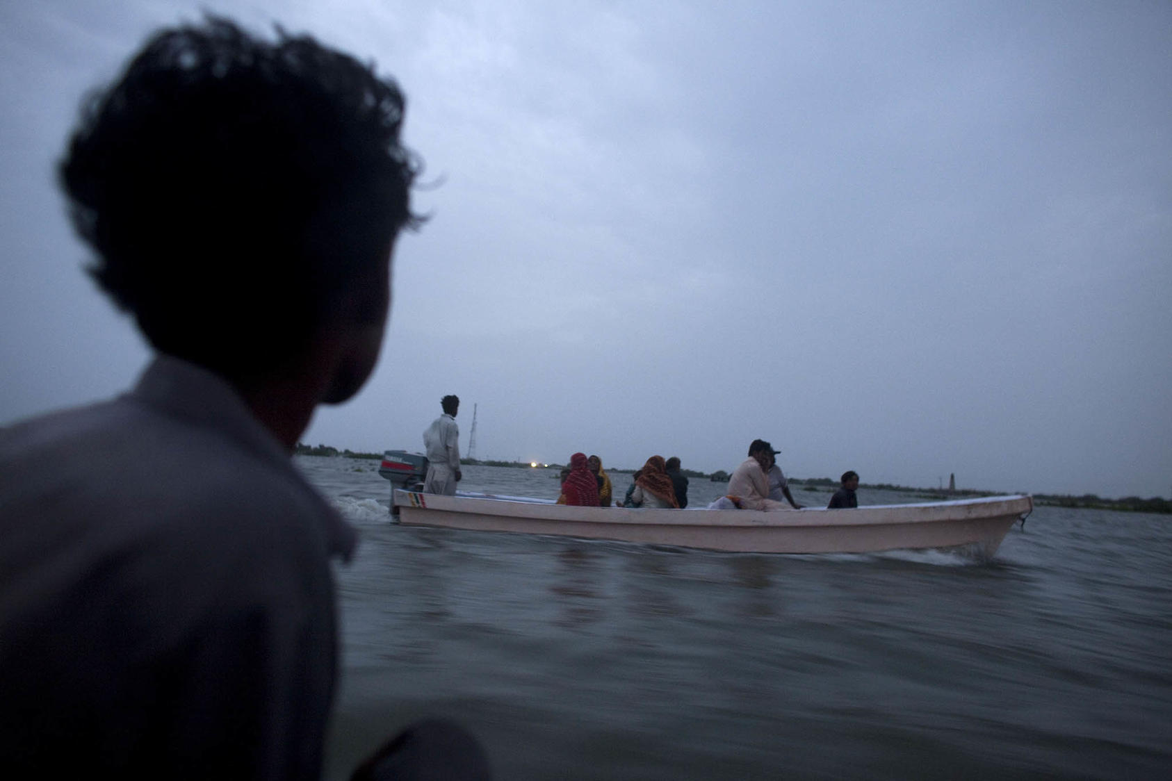 Rescue boats take displaced people to the area of Thatta, where thousands took refuge, in a small village next to Sujawal, Pakistan, Aug. 30, 2010. (Tyler Hicks/The New York Times)