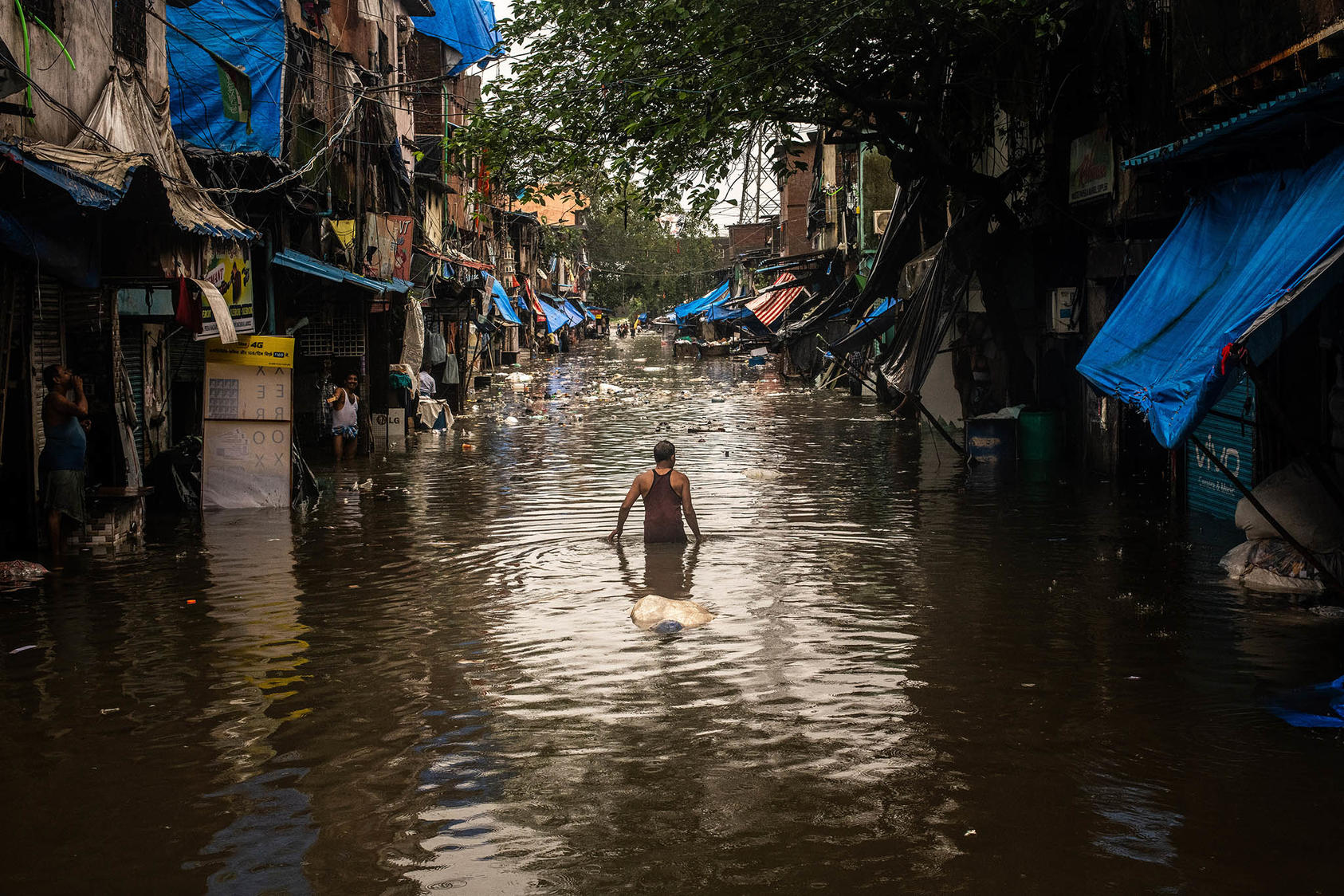 A man walks through a flooded street in the Scion neighborhood, along the Mithi River, of Mumbai, India, Aug. 4, 2019. (Bryan Denton/The New York Times)