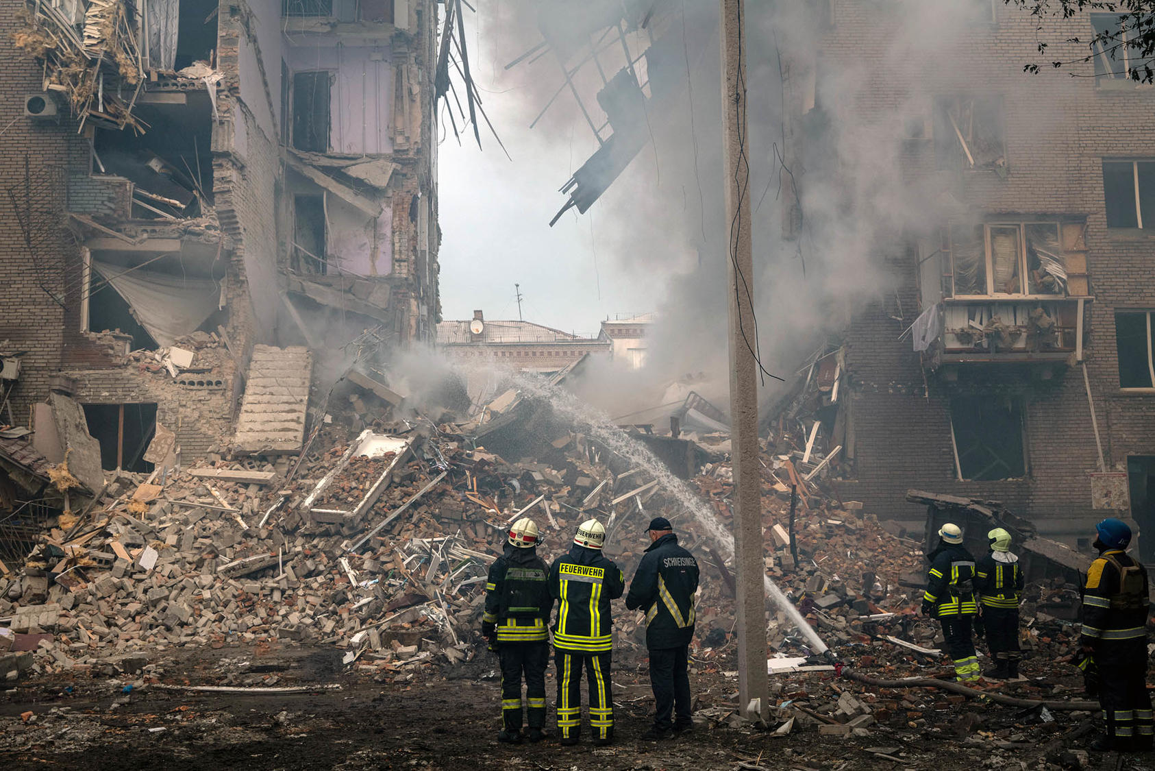 Ukrainian rescuers extinguish fires from an October 10 Russian missile strike in Zaporizhzhia, part of Russia’s aerial blitz targeting civilian homes and infrastructure vital to Ukrainians’ survival in the coming winter. (Nicole Tung/The New York Times)