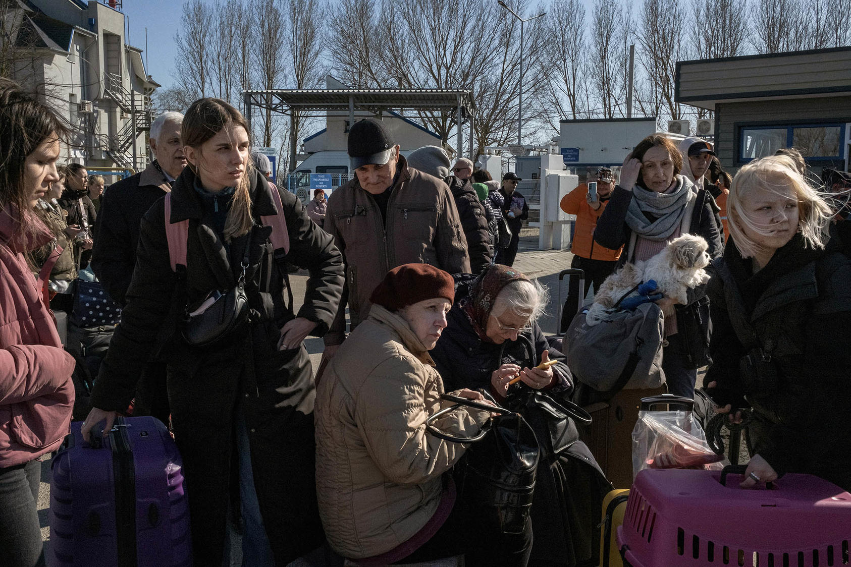 Ukrainians fleeing Russia’s new invasion wait for buses after crossing into Moldova in March. Moldova, Europe’s poorest country, hosts 85,000 refugees — and the entire population faces power and heat outages this winter. (Mauricio Lima/The New York Times)