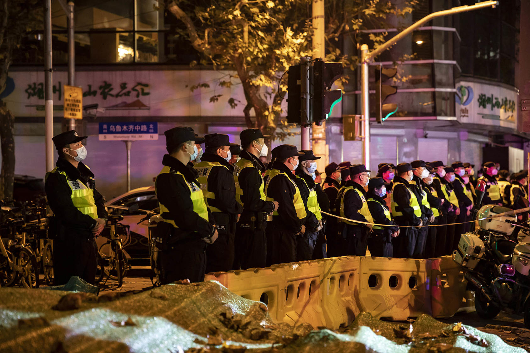 Police officers block a street where protests had taken place the night before, in Shanghai China, on Sunday, Nov. 27, 2022. (The New York Times)