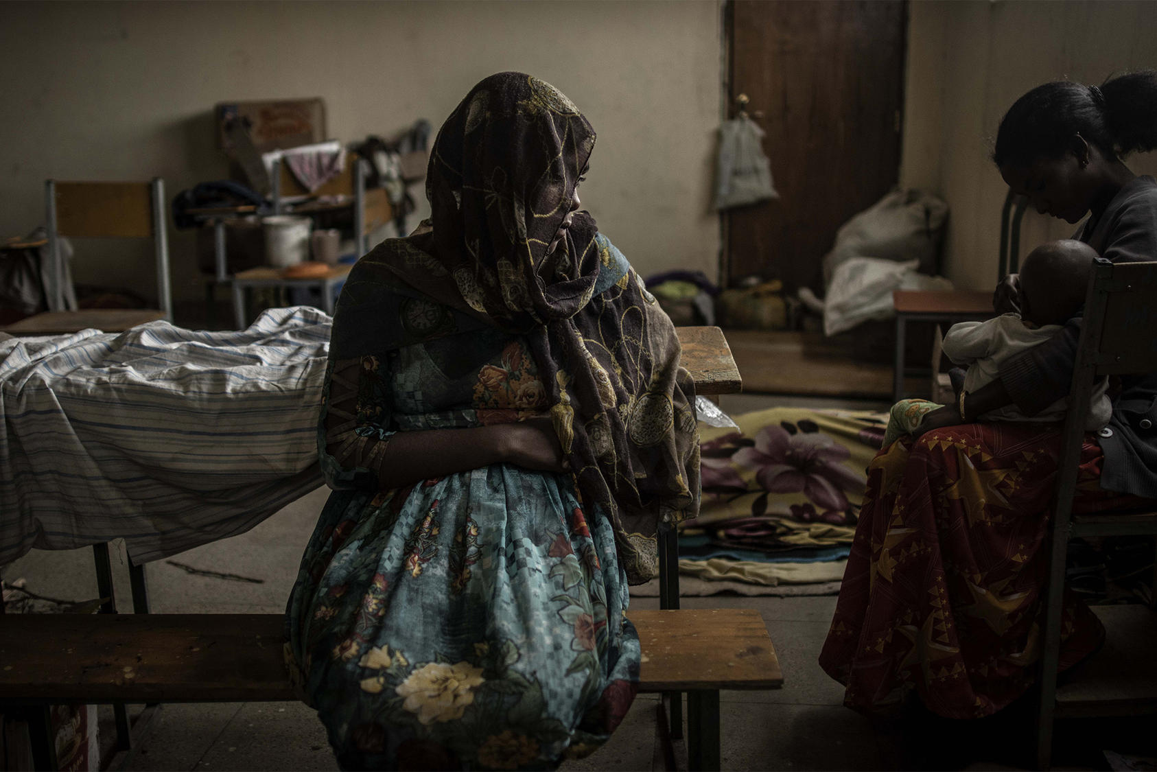 A woman sits at a school being used to house several thousand people displaced by fighting in Mekelle in Ethiopia's northern Tigray region. June 27, 2021. (Finbarr O’Reilly/The New York Times)