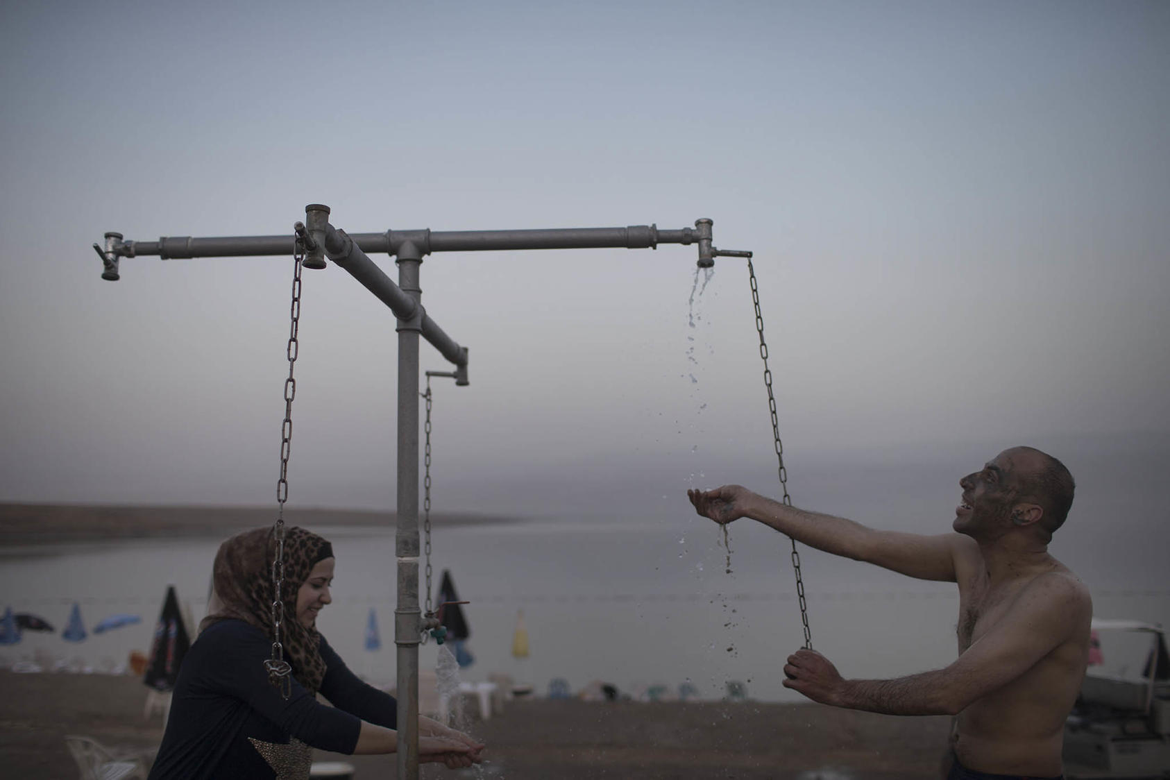 Palestinians use the showers at the beach at Kalia, in the West Bank, April 28, 2015. (Uriel Sinai/The New York Times)