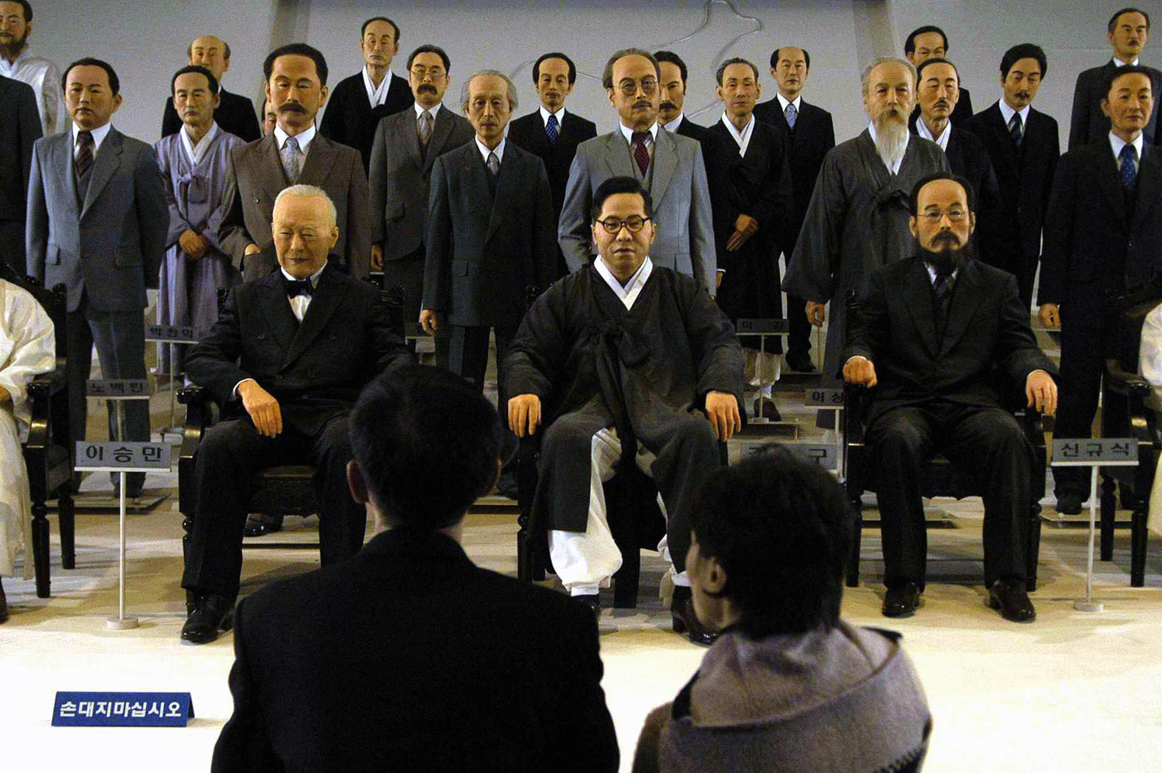 Visitors look at a display of life-size models of Koreans who resisted Japanese imperialism in Cheonan, South Korea, on Dec. 8, 2004. (Seokyong Lee/The New York Times)