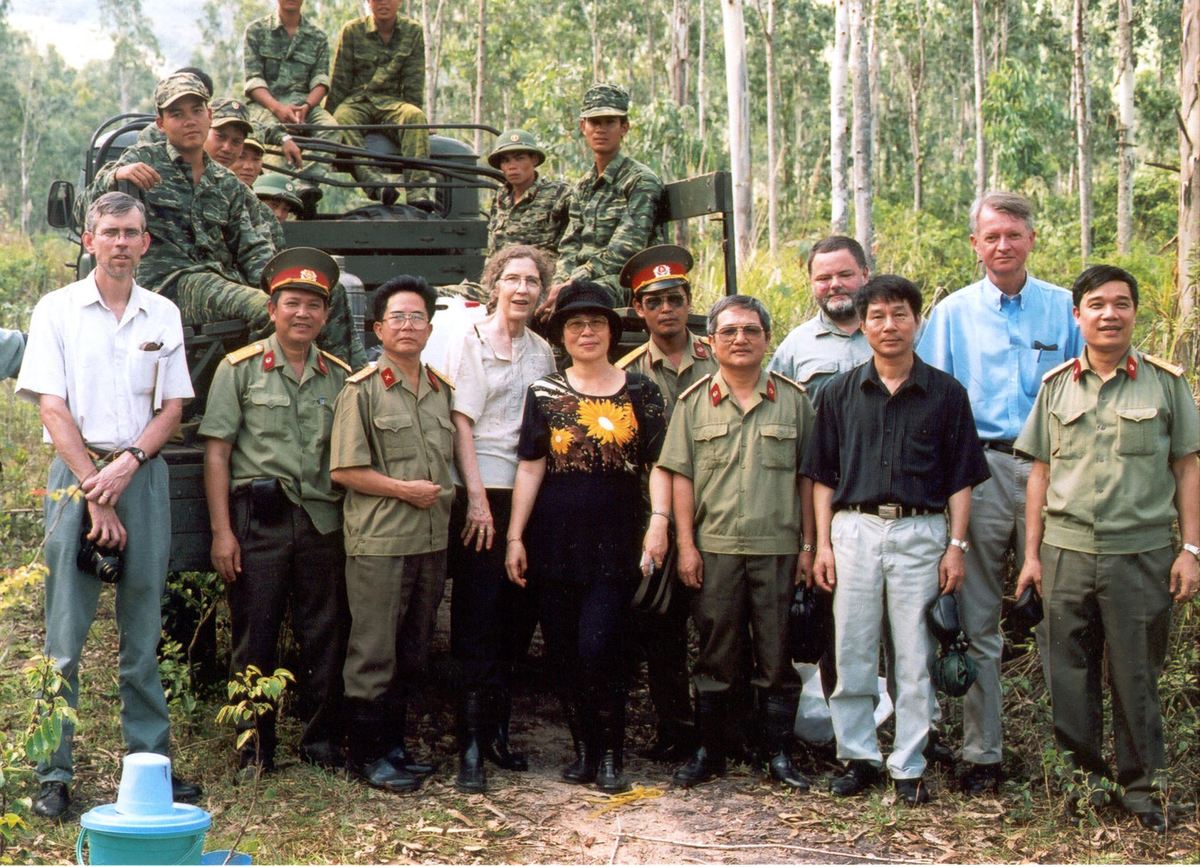 Chuck Searcy (second from right), Lady Borton (center, with her Vietnamese colleague Le Hoai Phuong), and Grant Bruce of Hatfield Consultants (far left) in 2001, at an army base in Quy Nhon. (Photo courtesy of George Black)