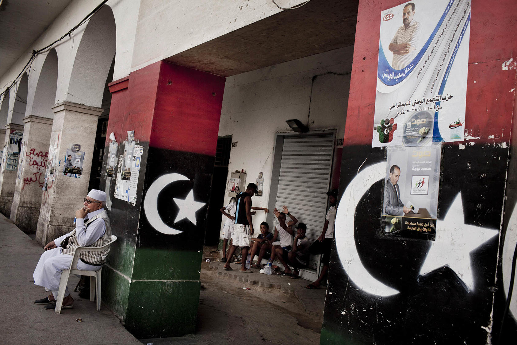 A man sits along a street littered ahead of Libya’s 2012 election in Tripoli, Libya. A new U.N. plan aims to have the country hold elections this year, but many Libyans want to focus on national reconciliation. (Tomas Munita/The New York Times)