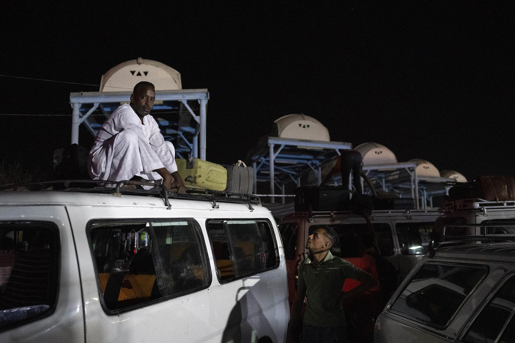 Taxi drivers await the arrival of refugees from Sudan at the bus station in Aswan, Egypt, on Wednesday night, May 3, 2023. (Heba Khamis/The New York Times)