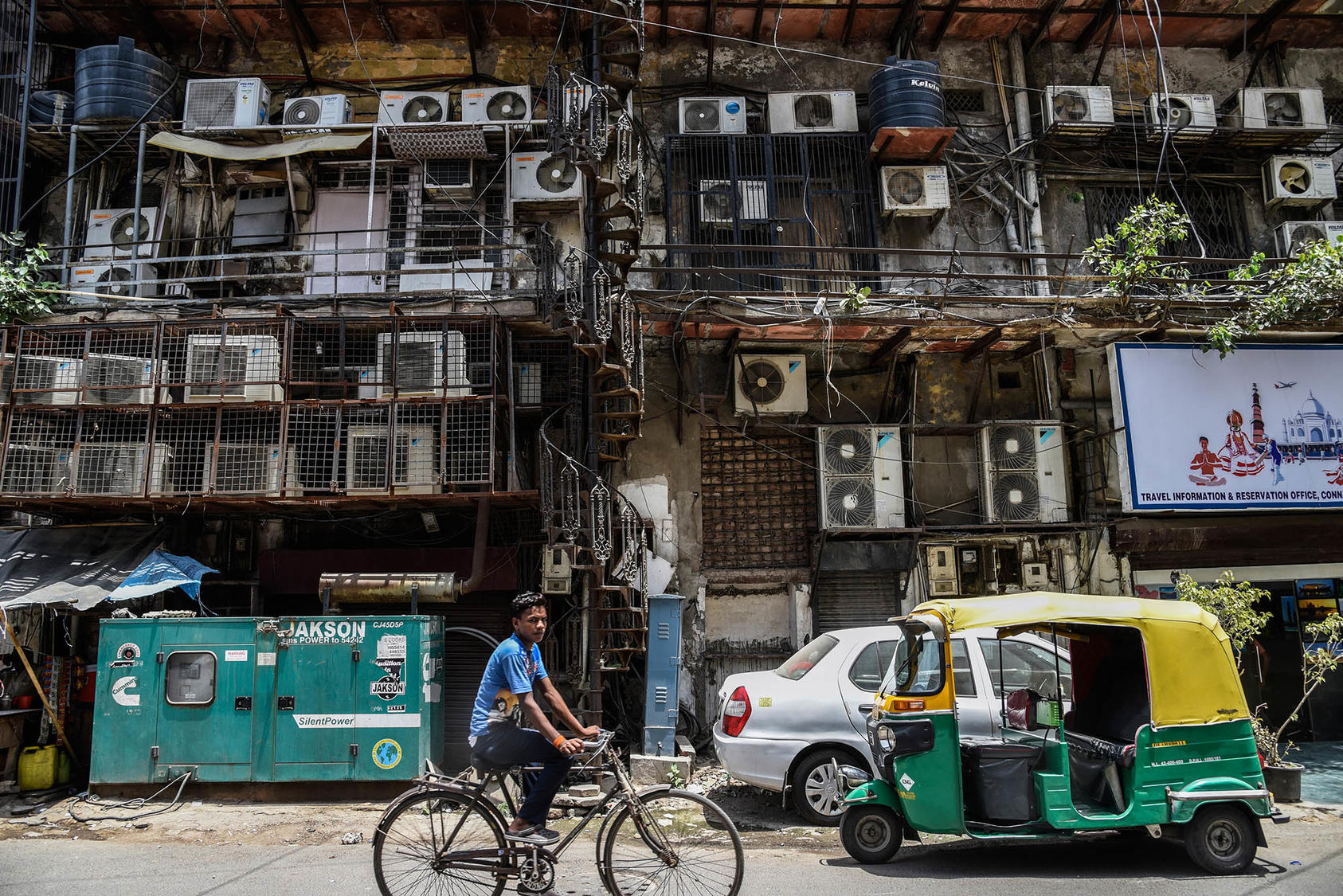 A man cycles past a facade with rows of air conditioners on a hot summer afternoon in New Delhi, Indian. In parts of Asia, temperatures and humidity levels are rising to levels that the human body can’t tolerate. (Saumya Khandelwal/The New York Times)