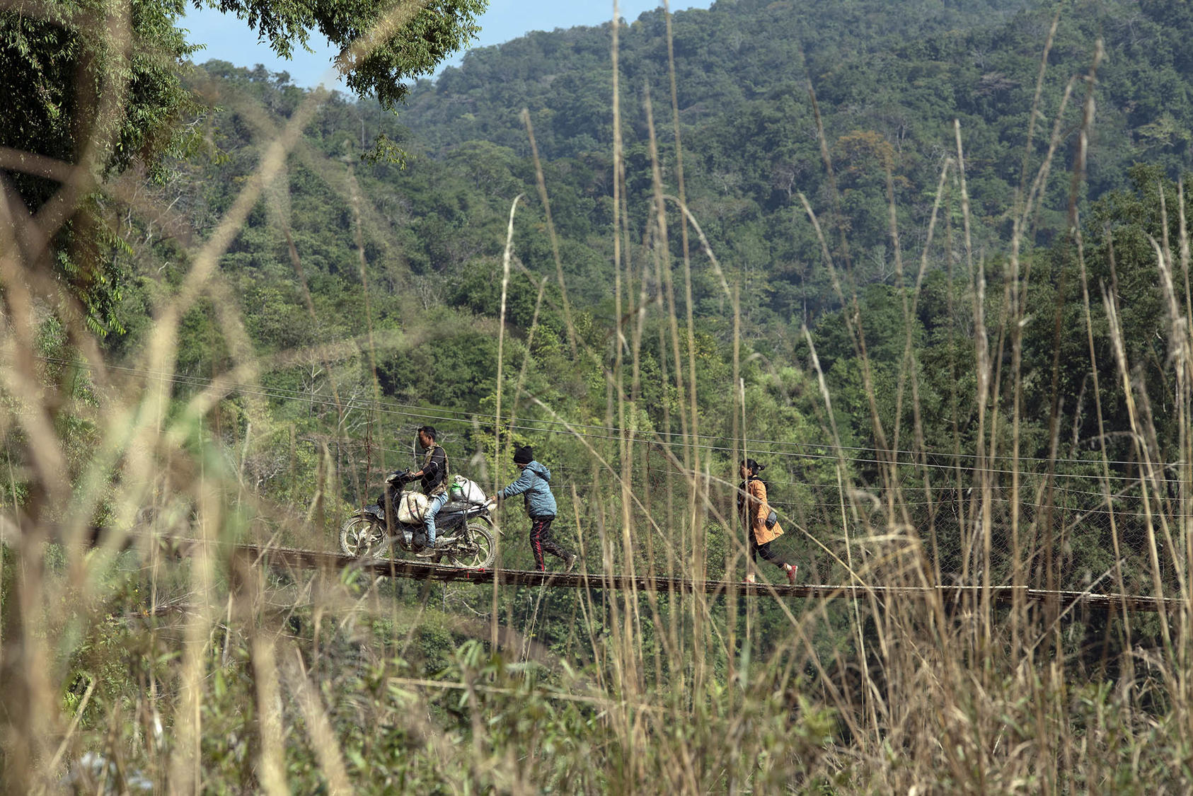 Refugees cross over from Myanmar into Mizoram, India, on a wooden bridge over the Tiau River on Dec. 12, 2021. (Saumya Khandelwal/The New York Times)